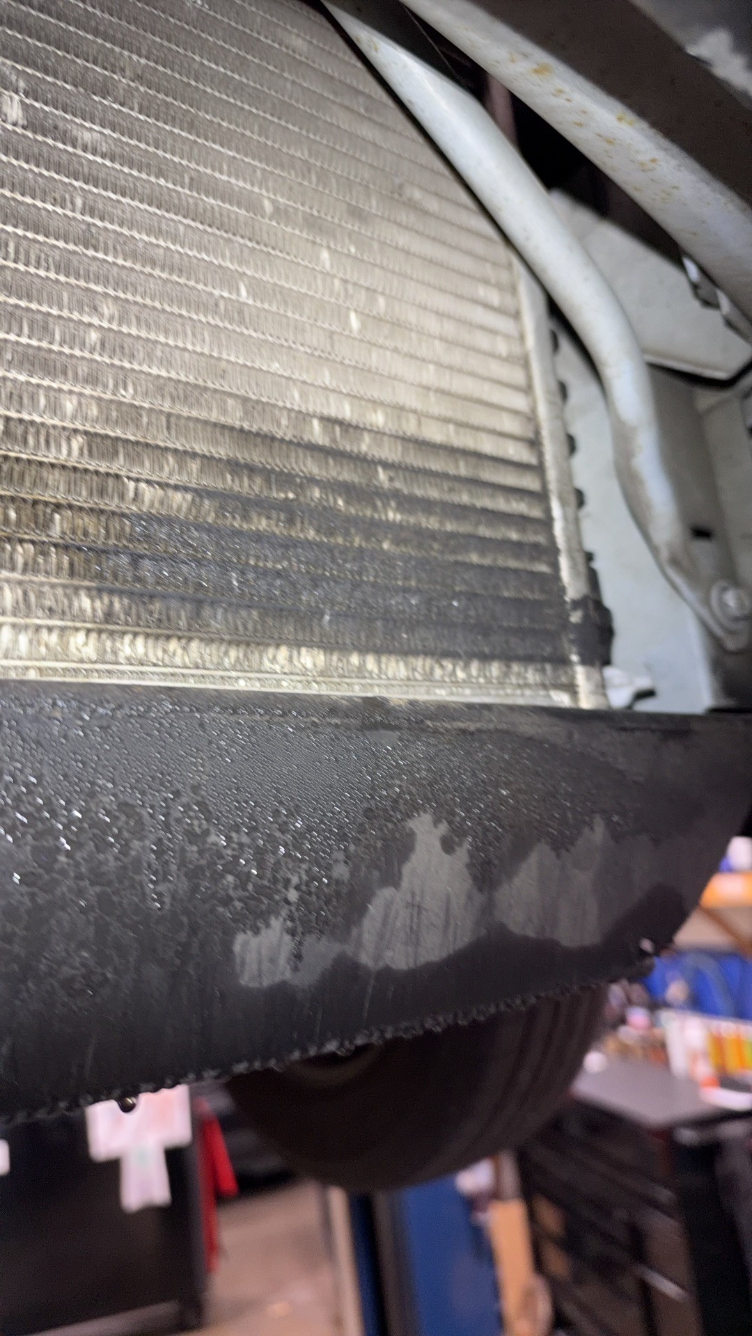 Bottom corner of the Pontiac Sunfire’s A/C condenser, wet and dirty from a leak
