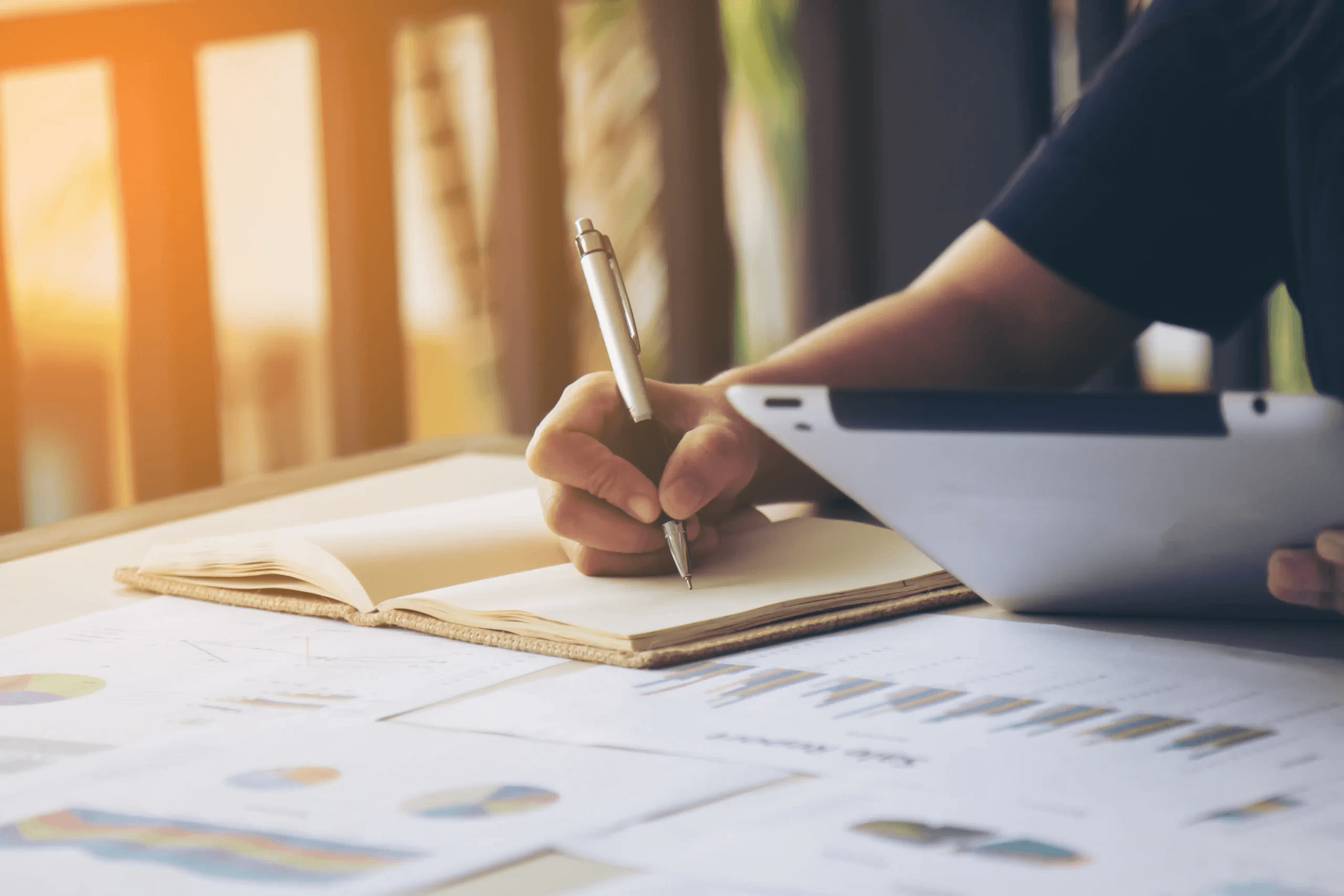 Person writing in notebook - Business Report Writing