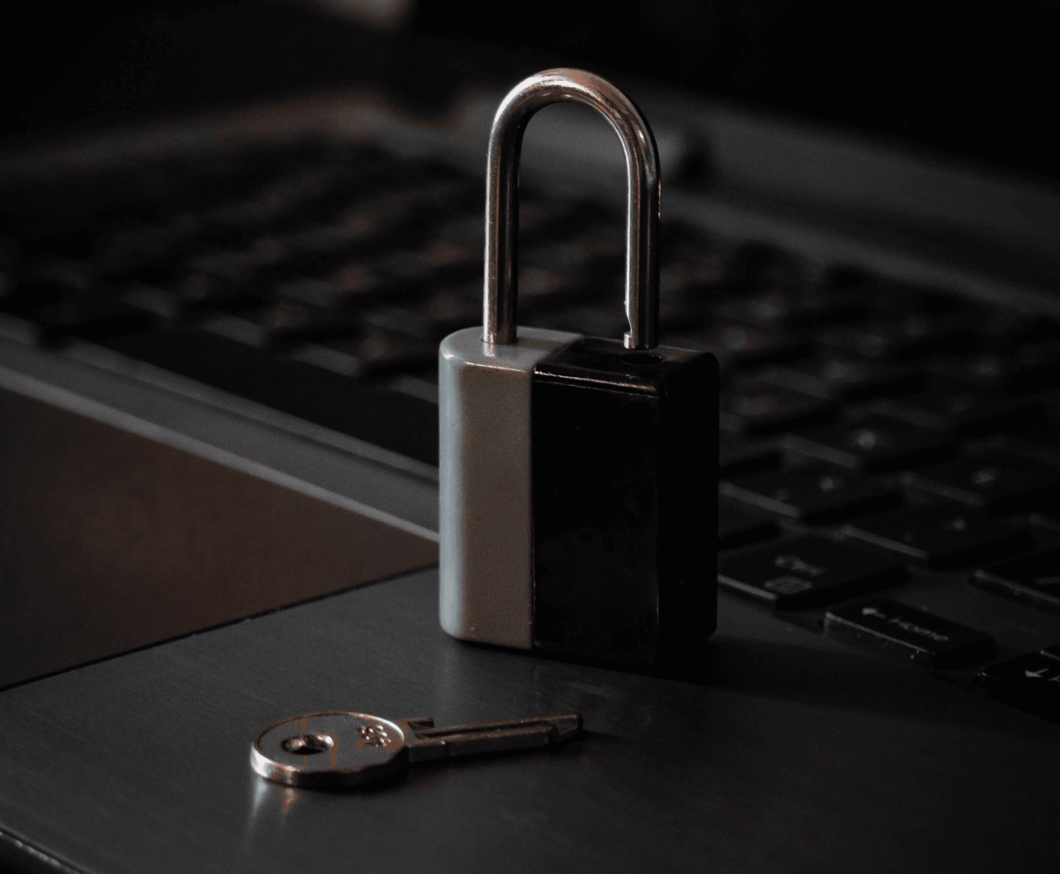A historic village with stone buildings and a prominent bell tower, perched dramatically on a steep, eroding hilltop, accessed by a long, elevated pedestrian bridge.