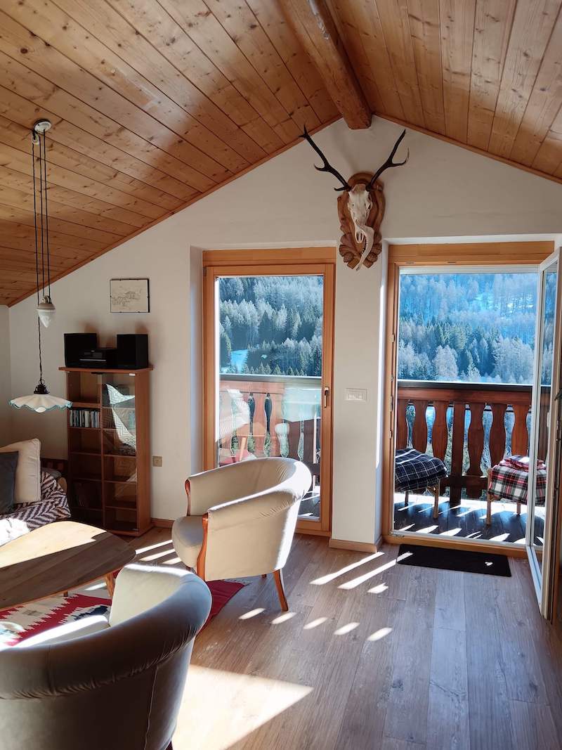 Living room of the apartment with a view of the balcony through the open glass door
