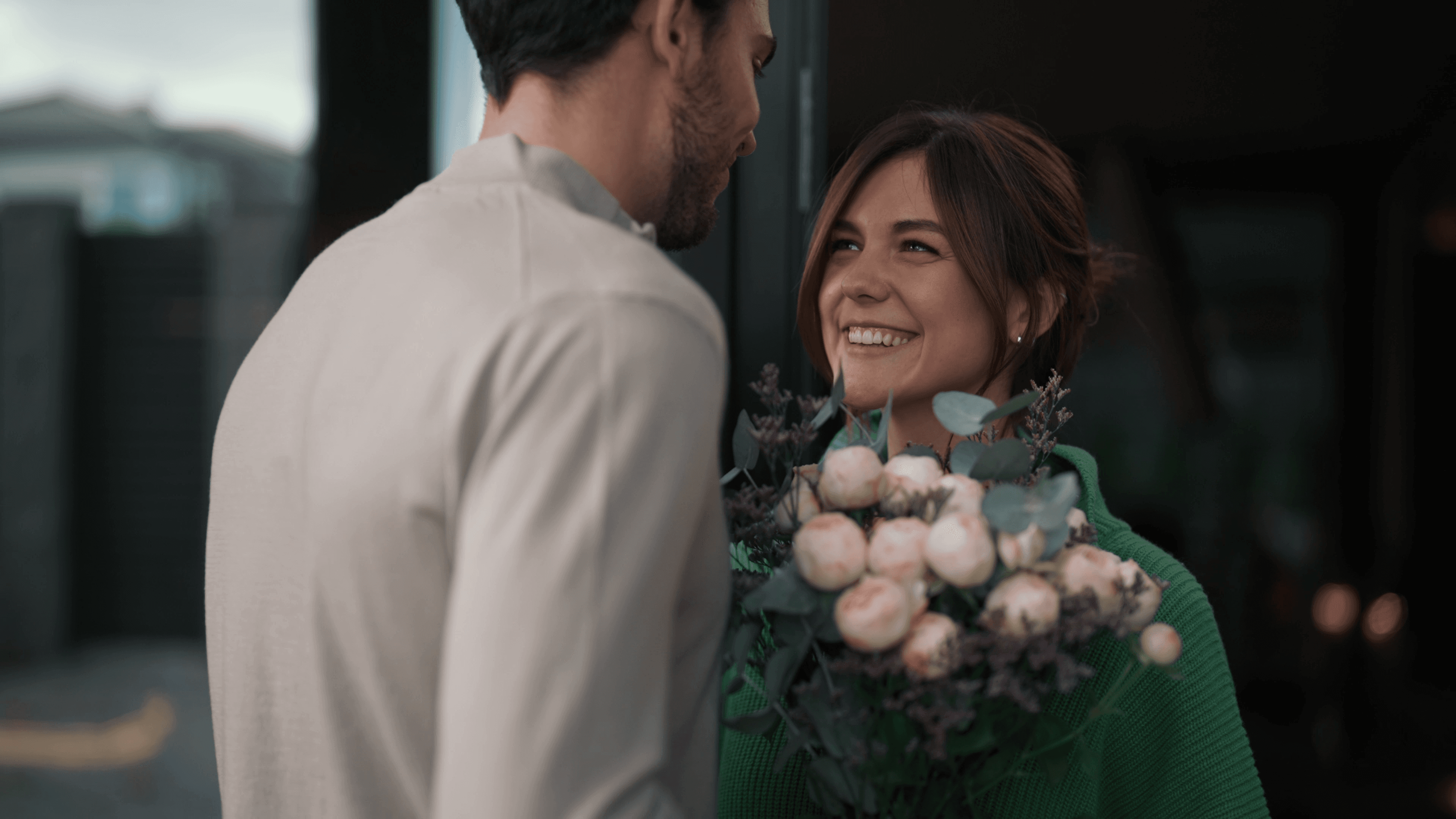A man in a suit gives flowers to a girl