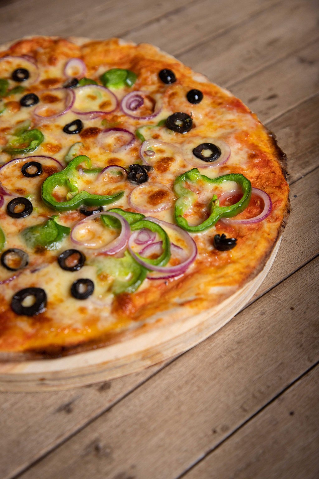 Thin crust pizza with pepper, olive and red onion