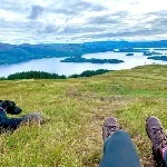 people on hike with dog on a hill with a beautiful view