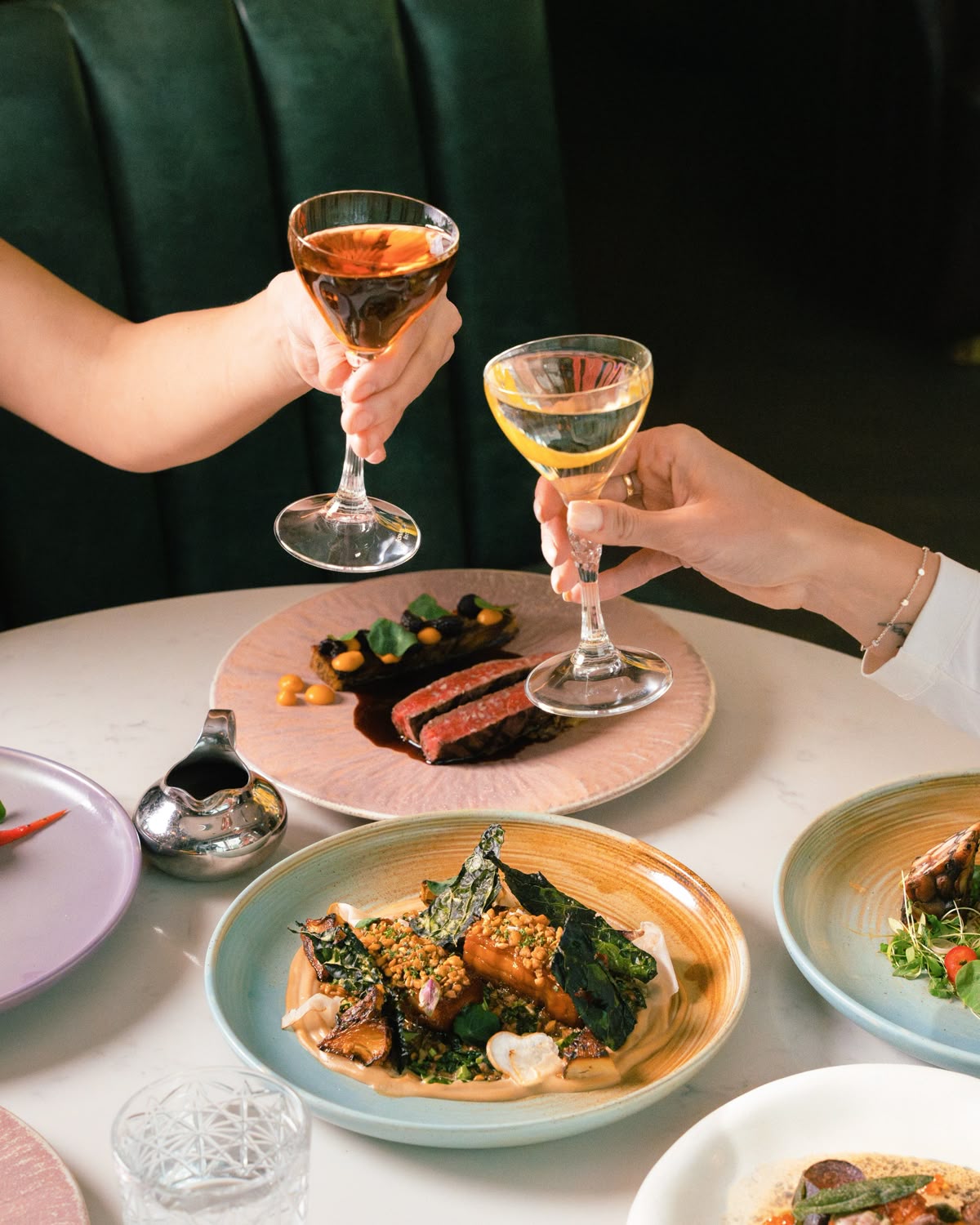 Guests toasting cocktails over gourmet plates at Dhoom Toronto, celebrating New Year’s Eve with elevated Indian cuisine and a luxury dining experience.