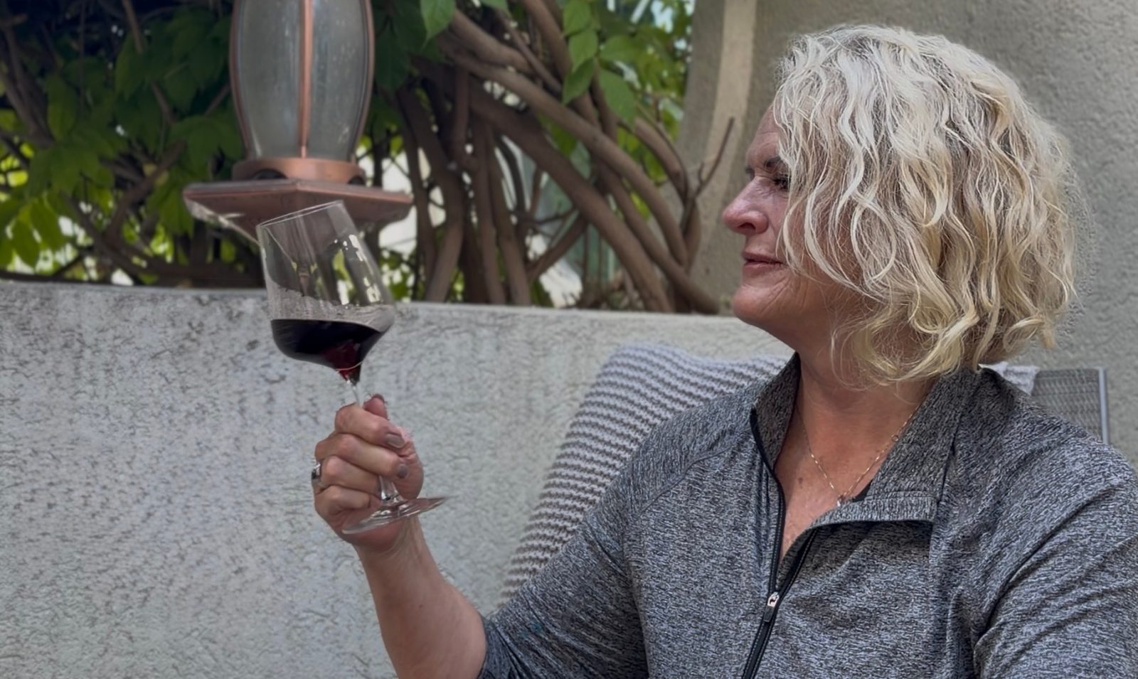 Tammy of Spoken Wines evaluating a glass of red wine during a tasting.