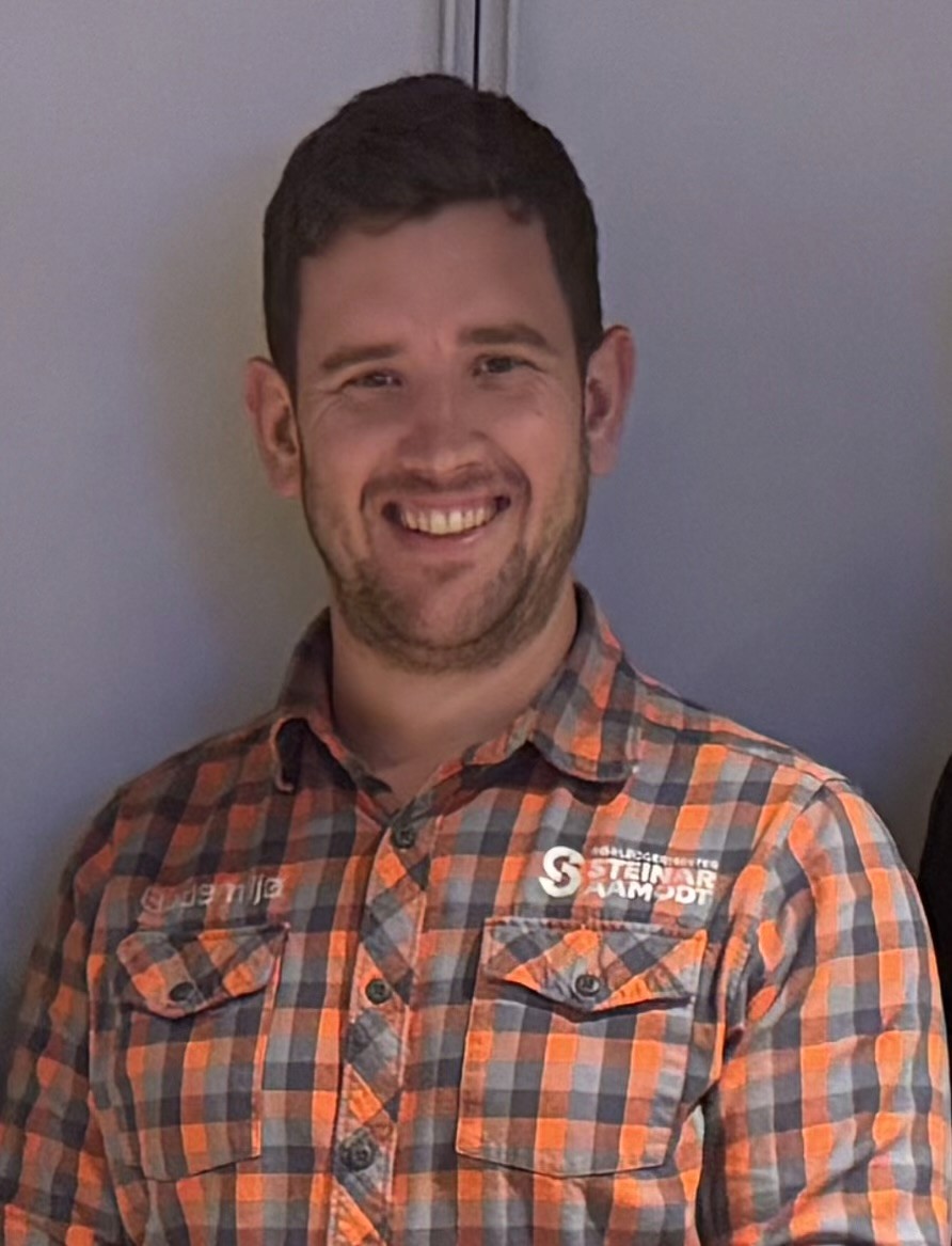 Mann i rutete skjorte med Bademiljø logo