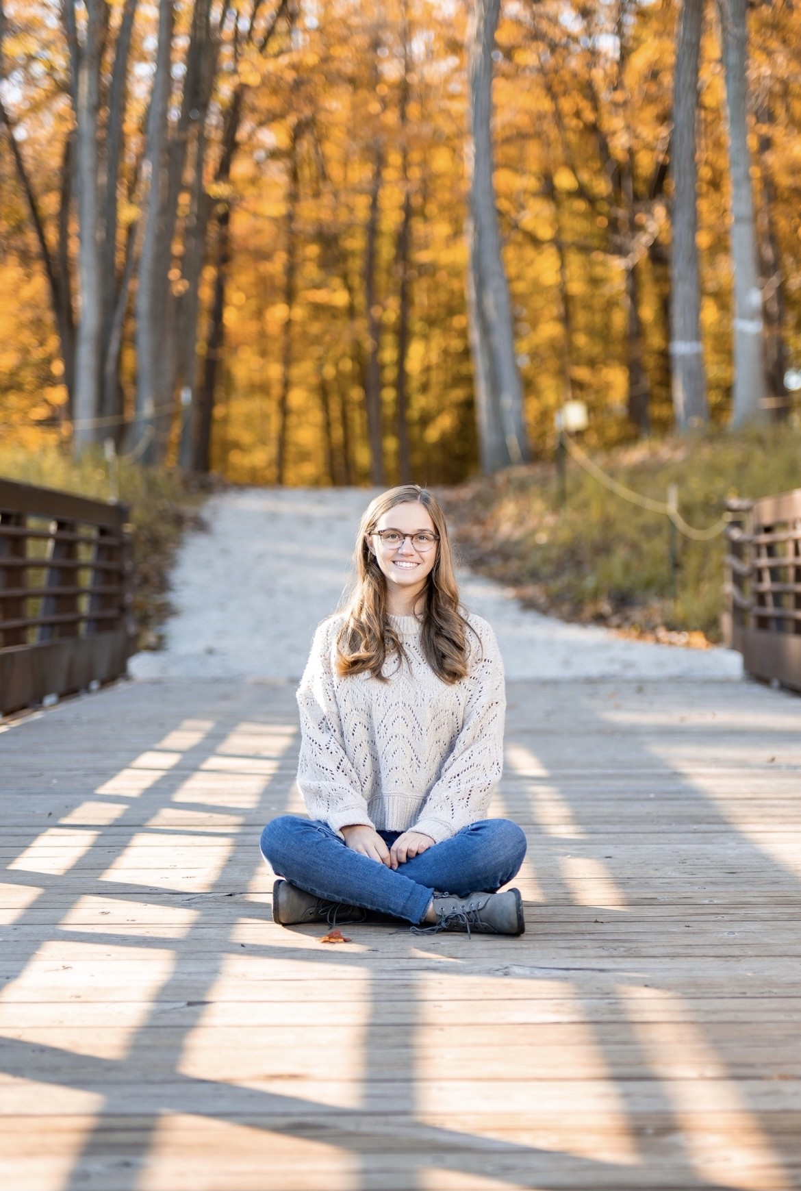 A thoughtful young person with dark hair gazes to the side, captured in soft black and white lighting.