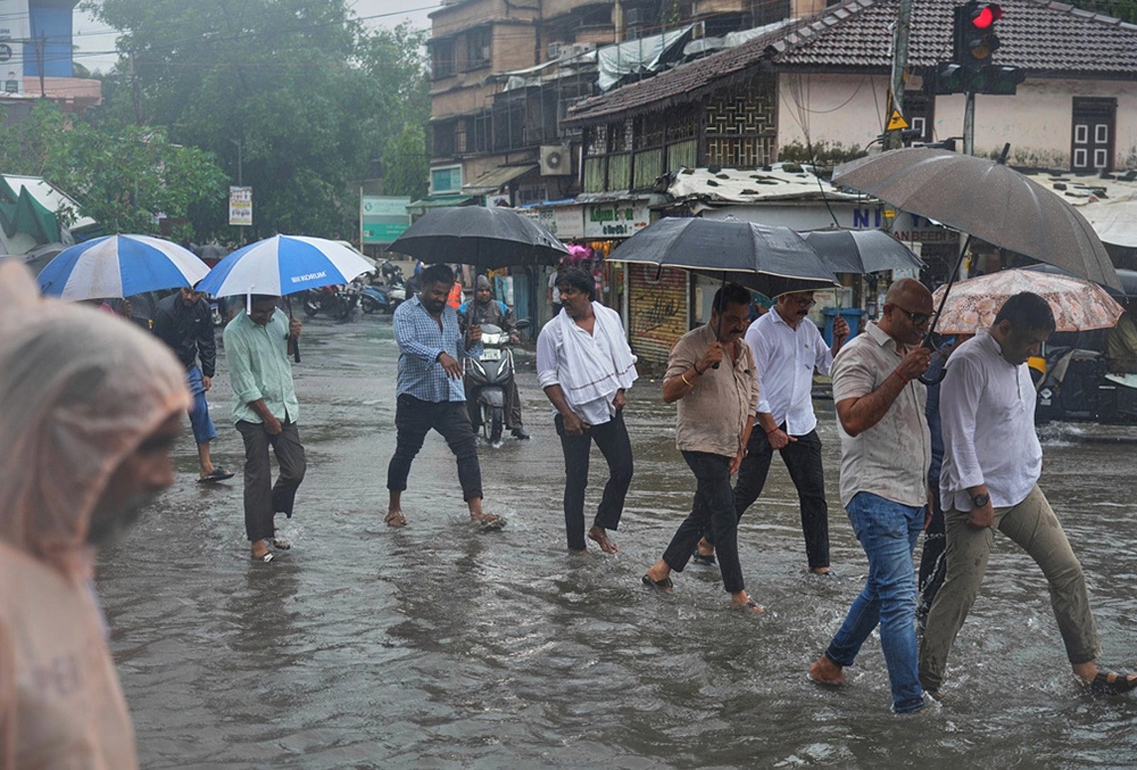 People hold umbrellas as they walk on a water-logged street during monsoon rains in Mumbai, July 6, 2026.