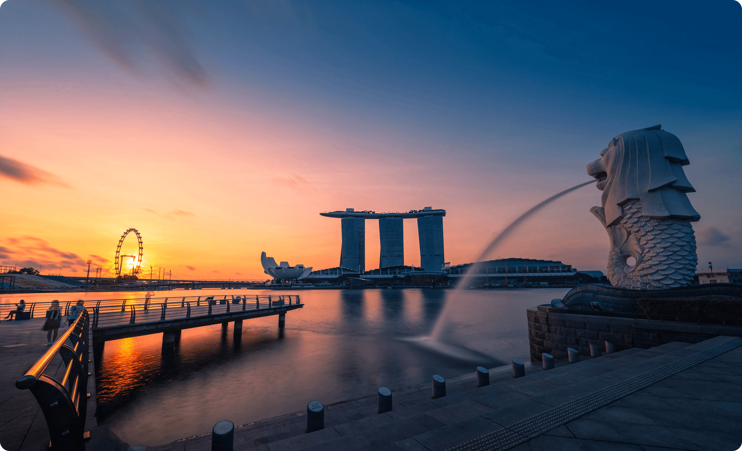 Sunrise cityscape with the Merlion fountain and Marina Bay waterfront.