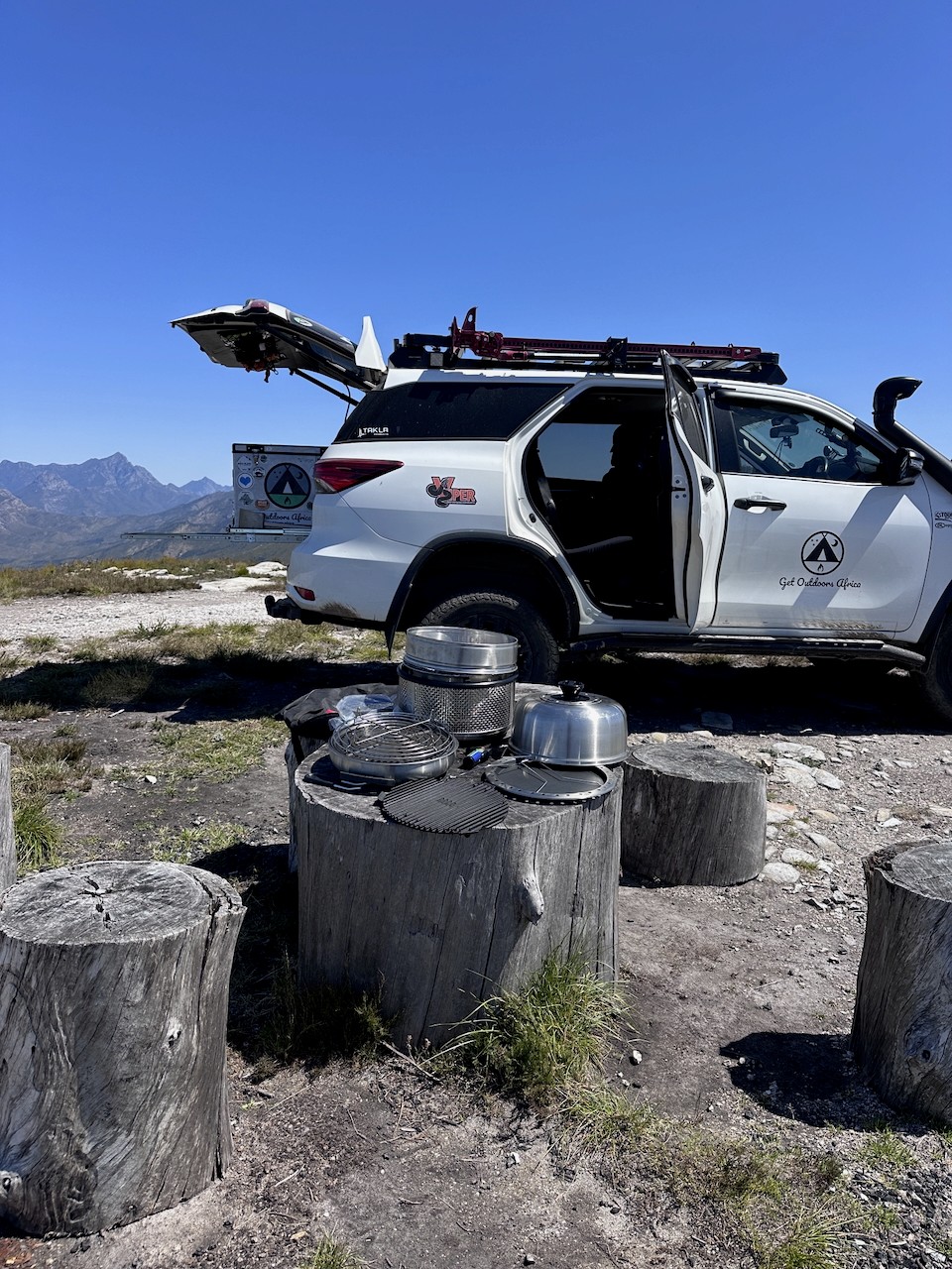 Dos mujeres disfrutando un asado en su parrilla COBB Premier al lado de un lago