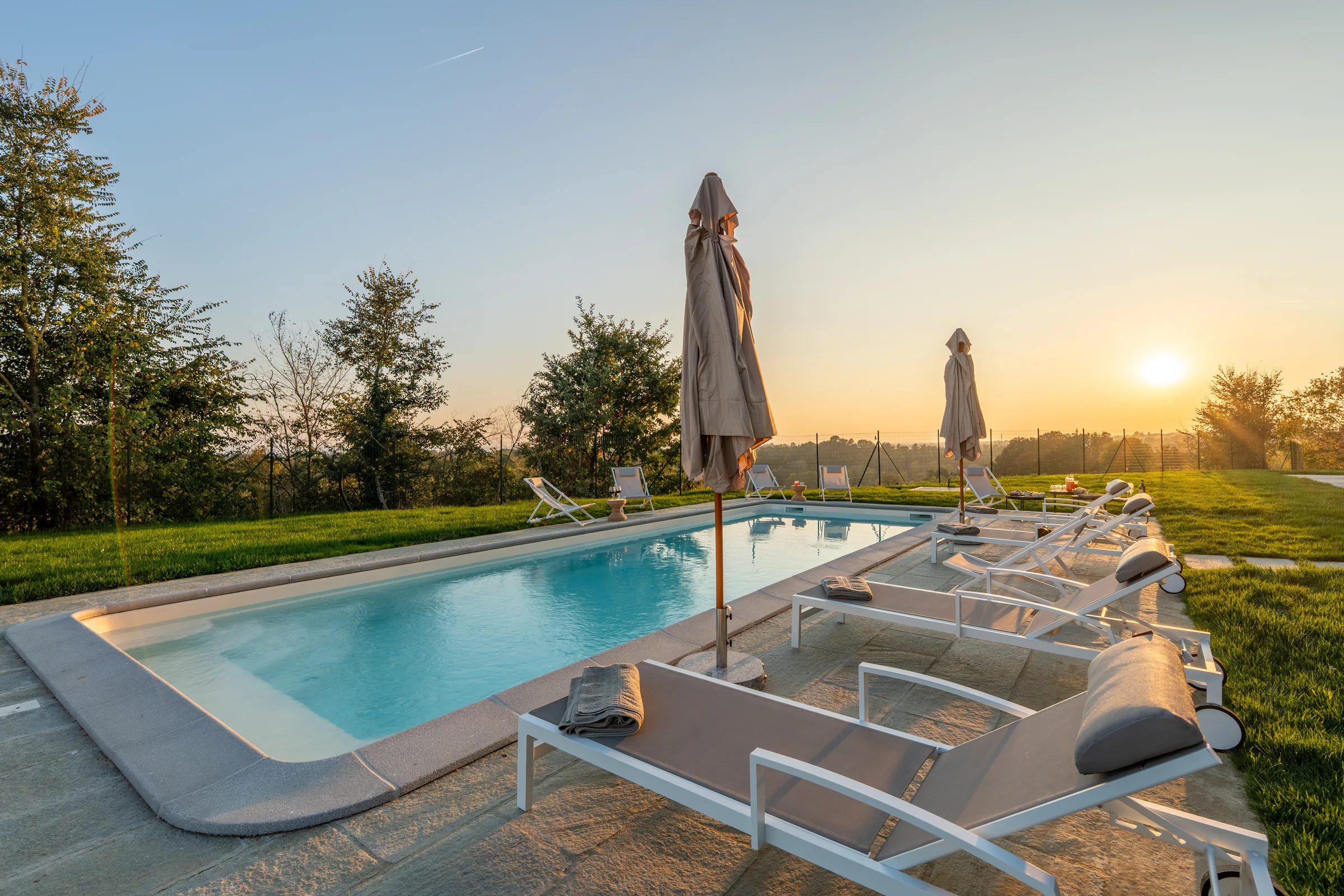 Swimming pool in warm sunset light — Fubine Monferrato, Italy. Photography by Yunes Calore.