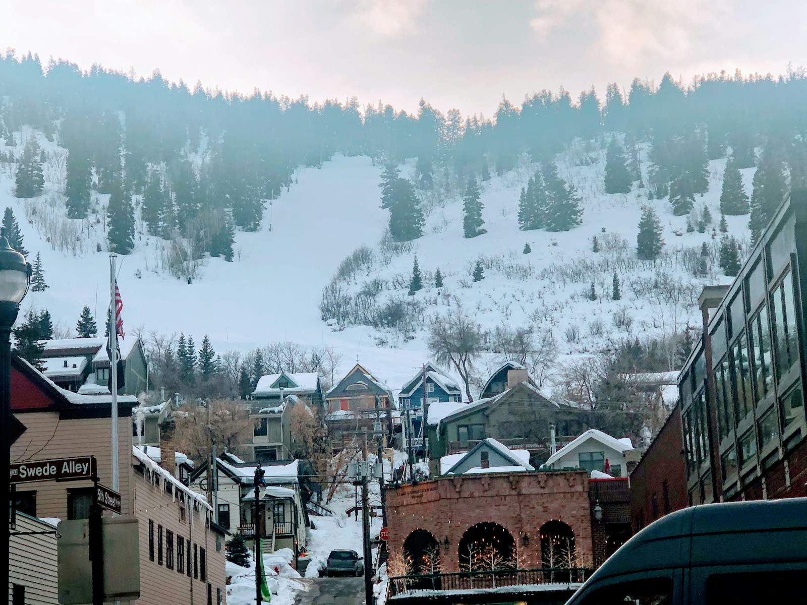 Snow-laden rooftops in Park City with the ski runs rising behind town