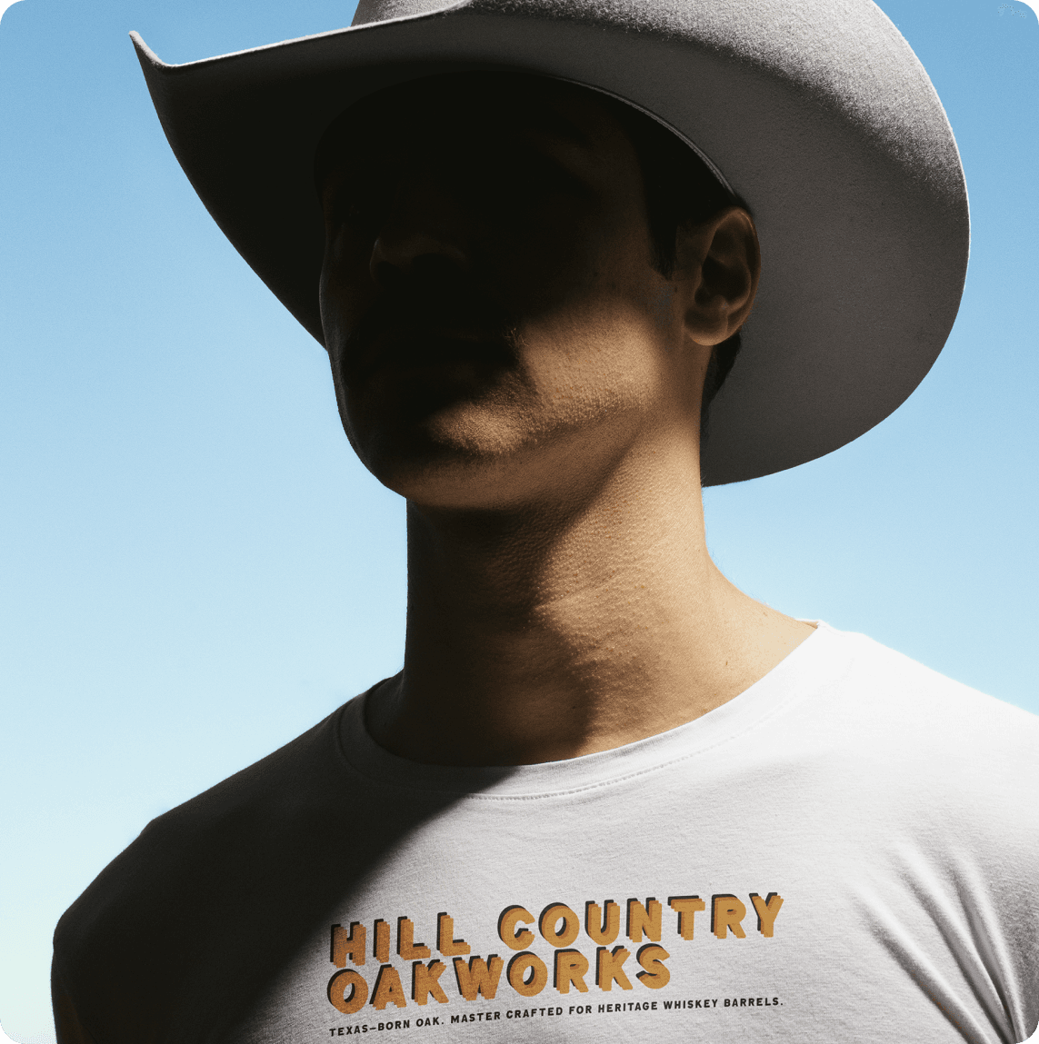Woman wearing sleeveless black midi dress with white floral print, styled with black oxford shoes against tropical leaves