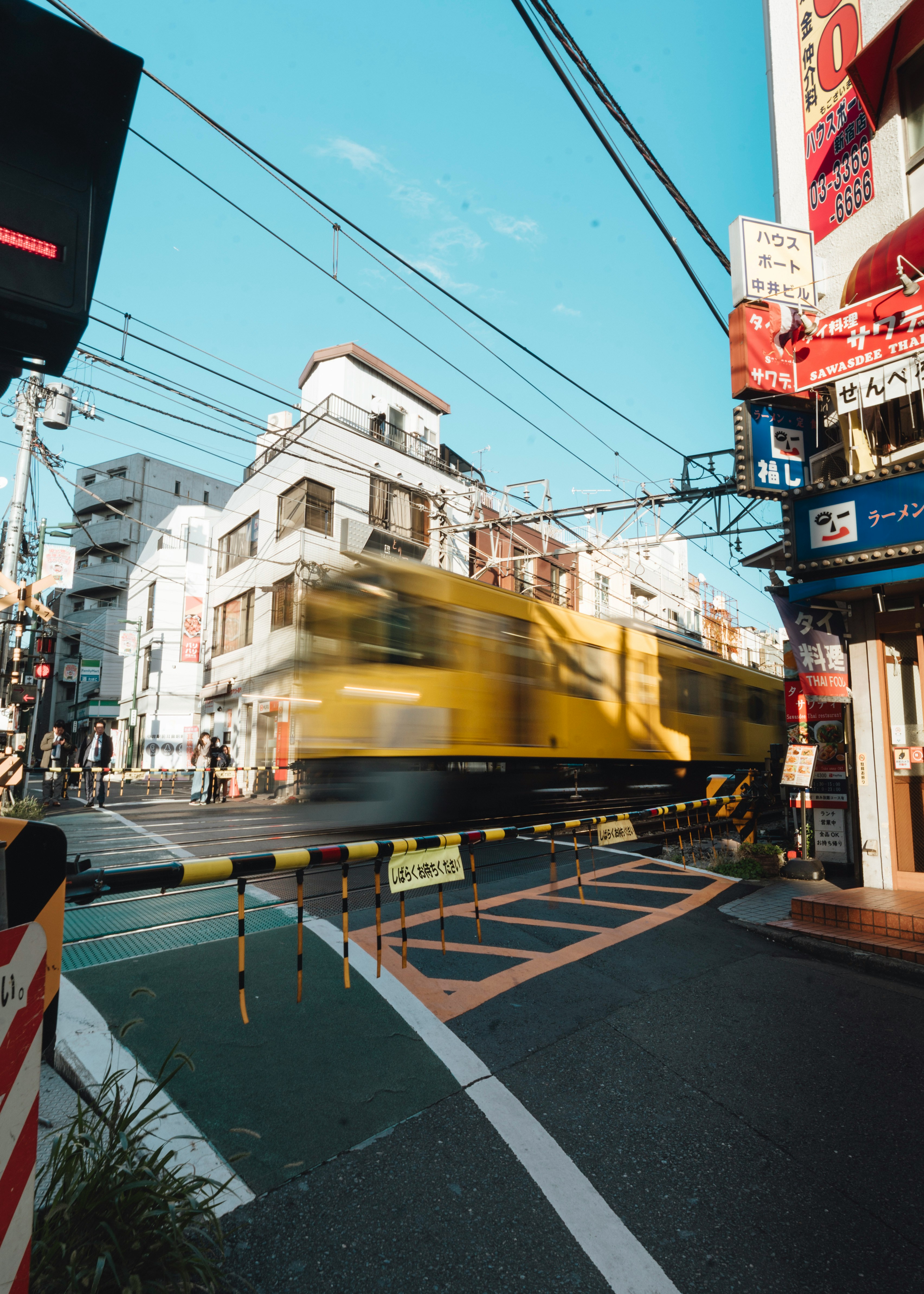 Yellow train passing through a city crossing