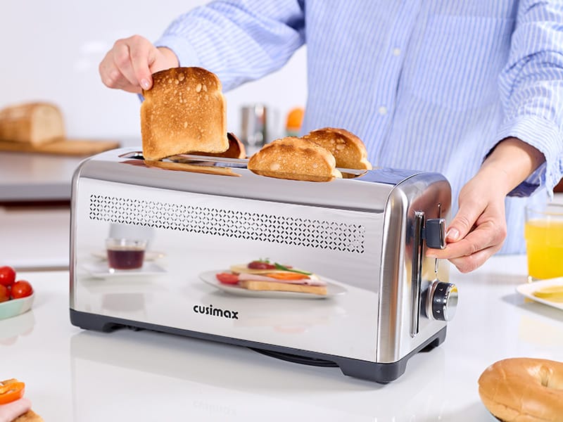 Person preparing golden toast with stainless steel Cusimax toaster in modern kitchen, lifestyle photography for ecommerce