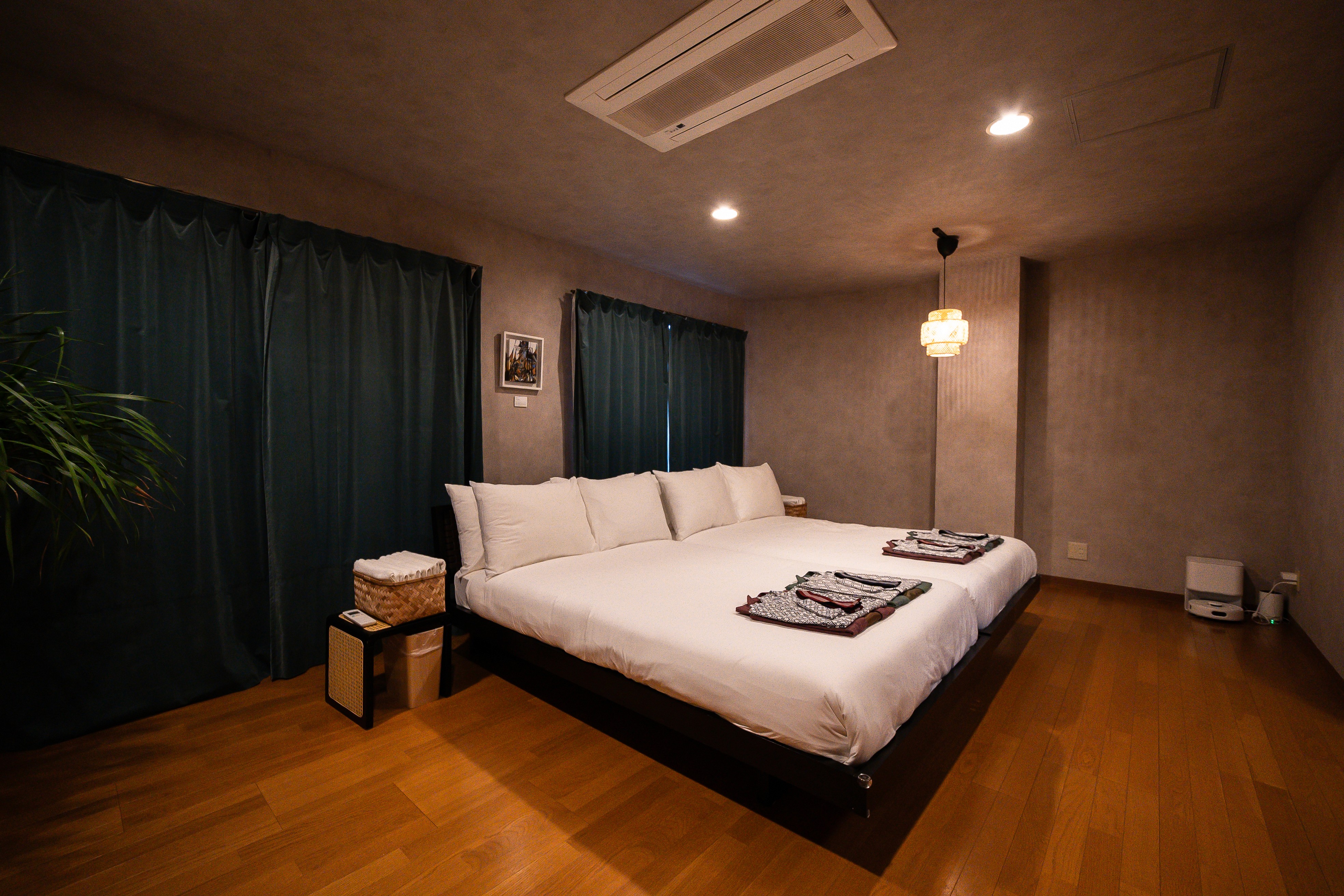 A beautiful traditional-style bedroom with paintings on the walls, a carpeted floor, and a chandelier overhead.