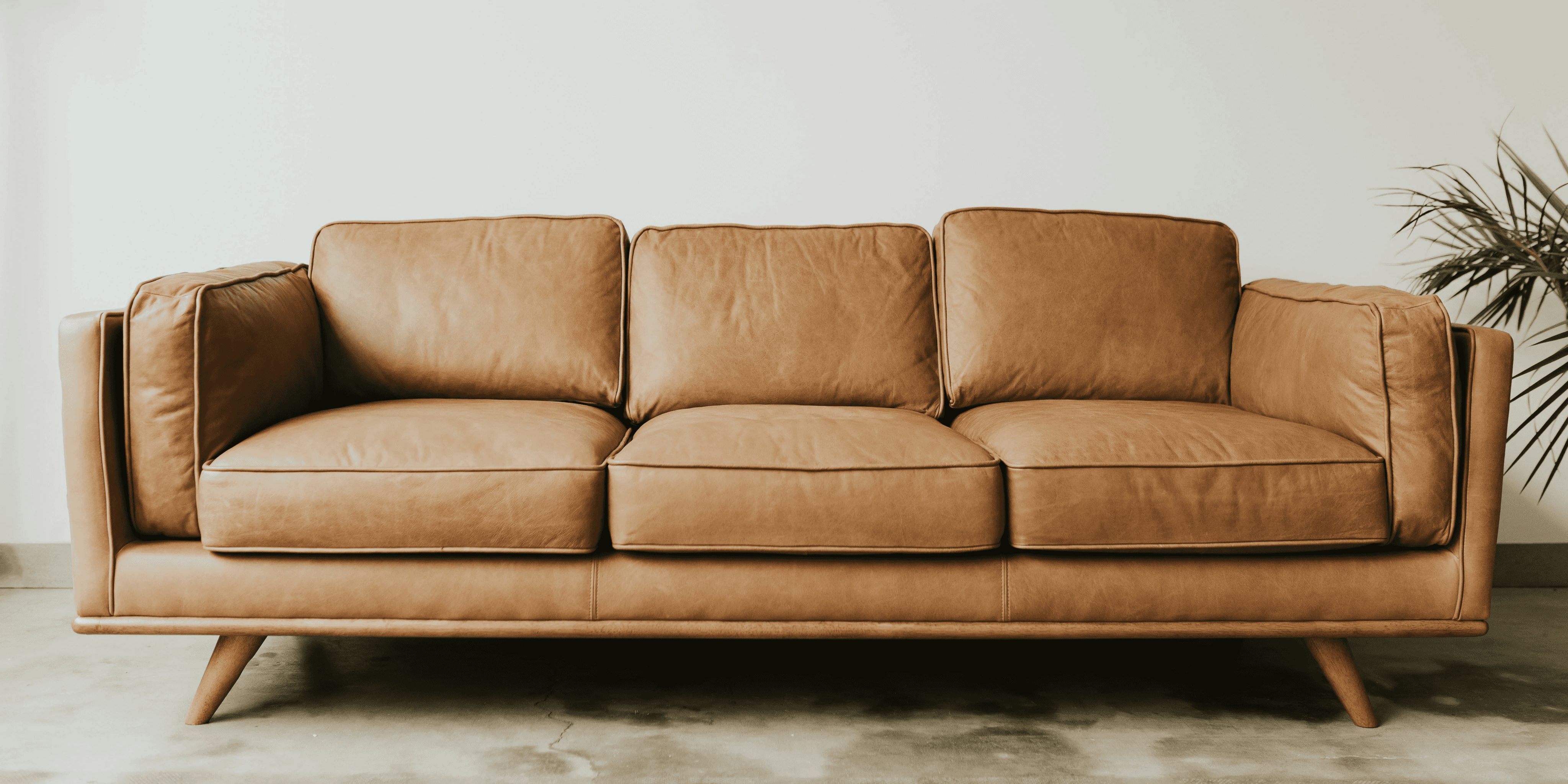 An image of a three-seater brown couch 