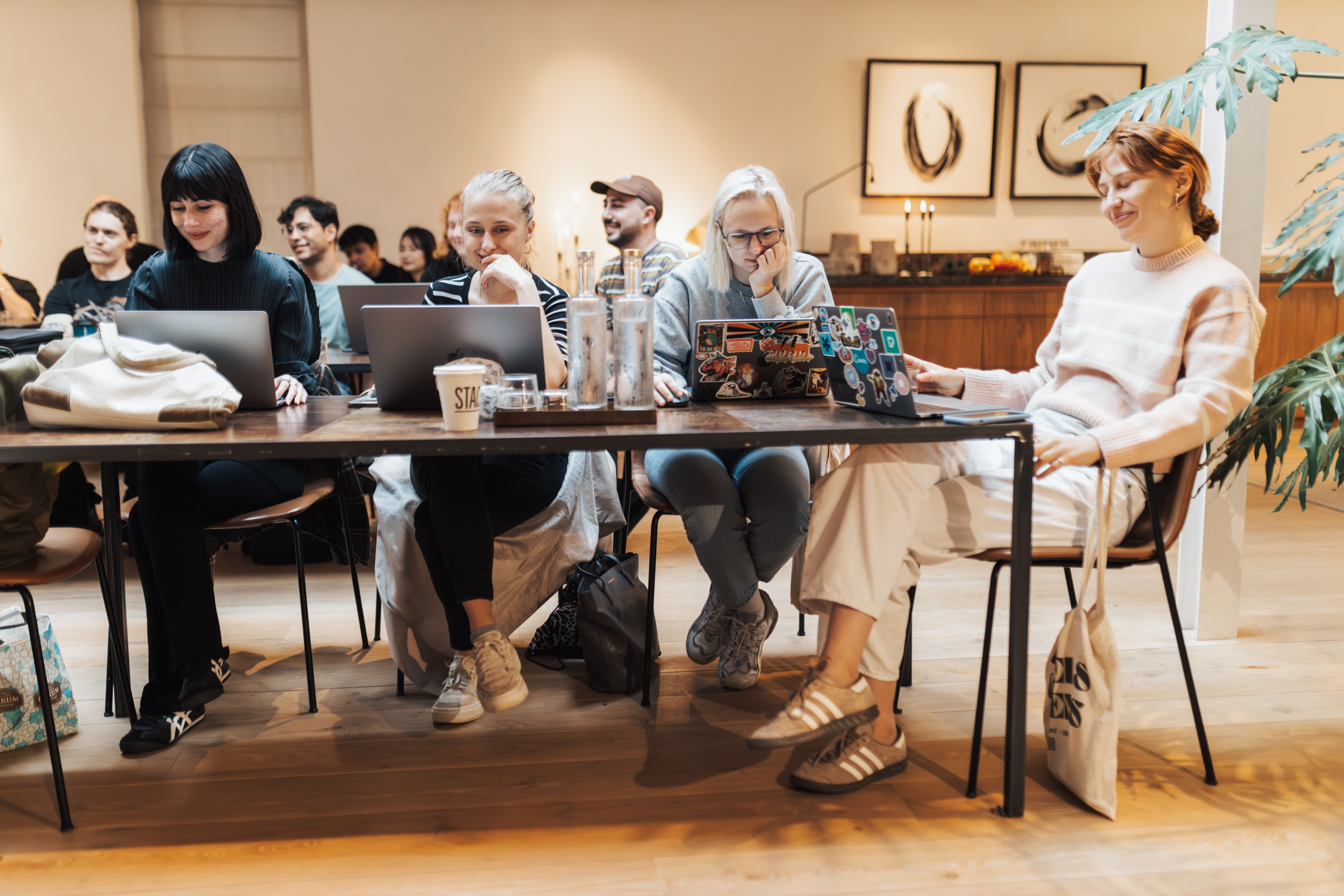 People talking over laptops at a shared table