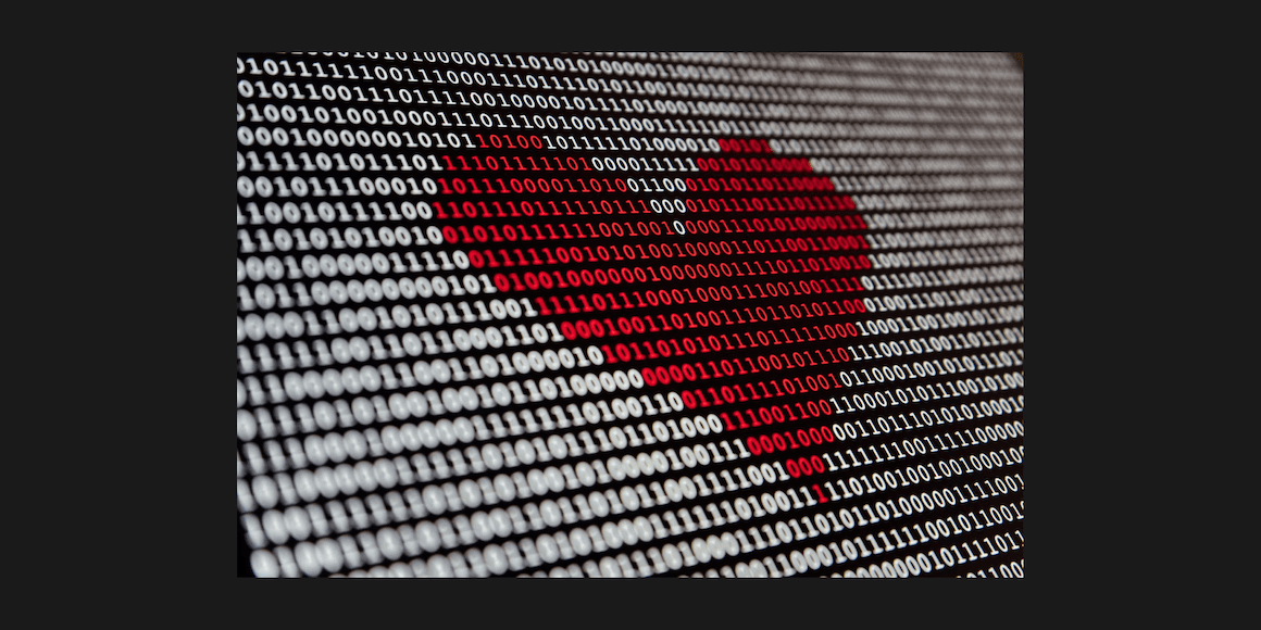 Composite photo of a broken red heart formed from binary code against a dark background