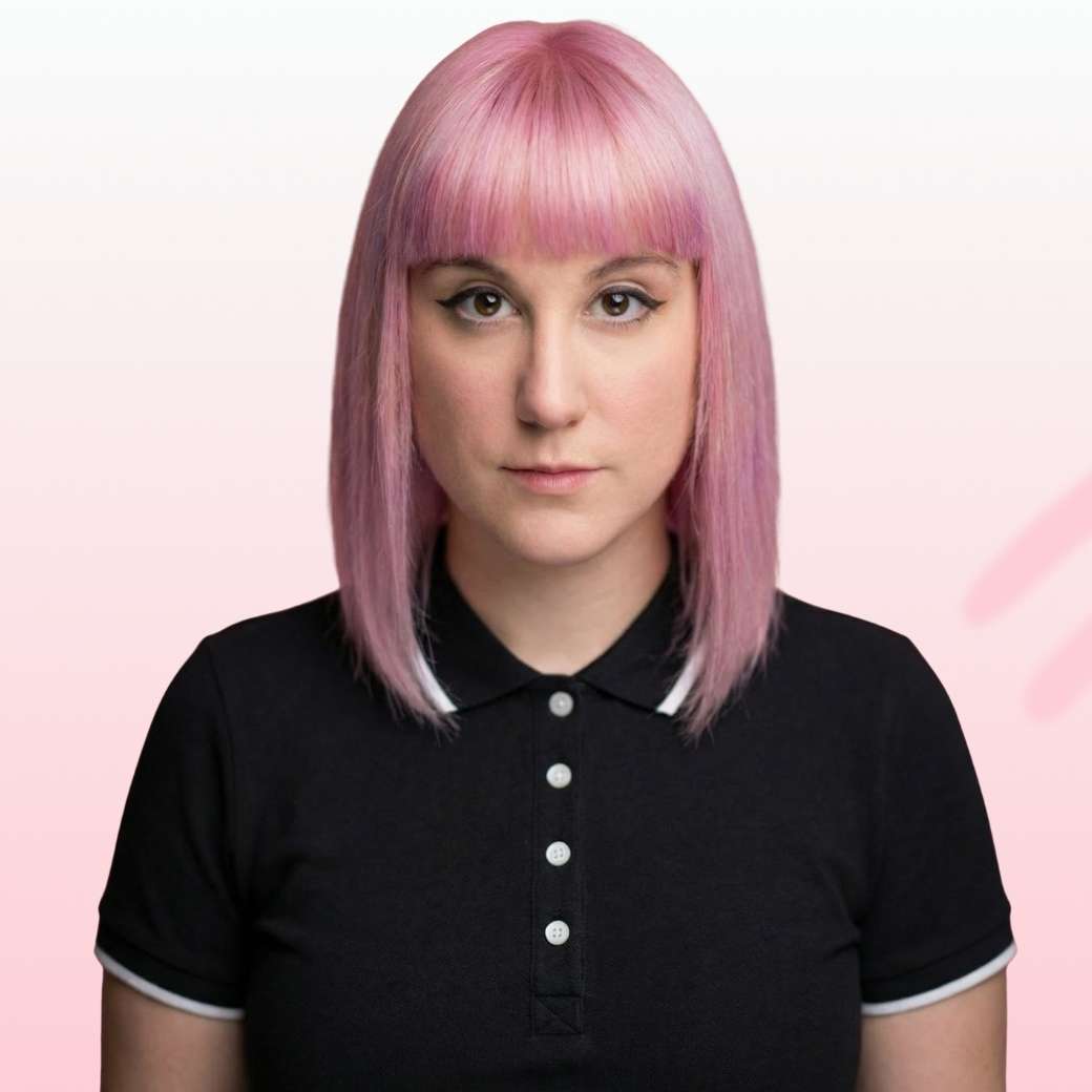 Smiling man with light brown hair and stubble, wearing a khaki shirt in natural light