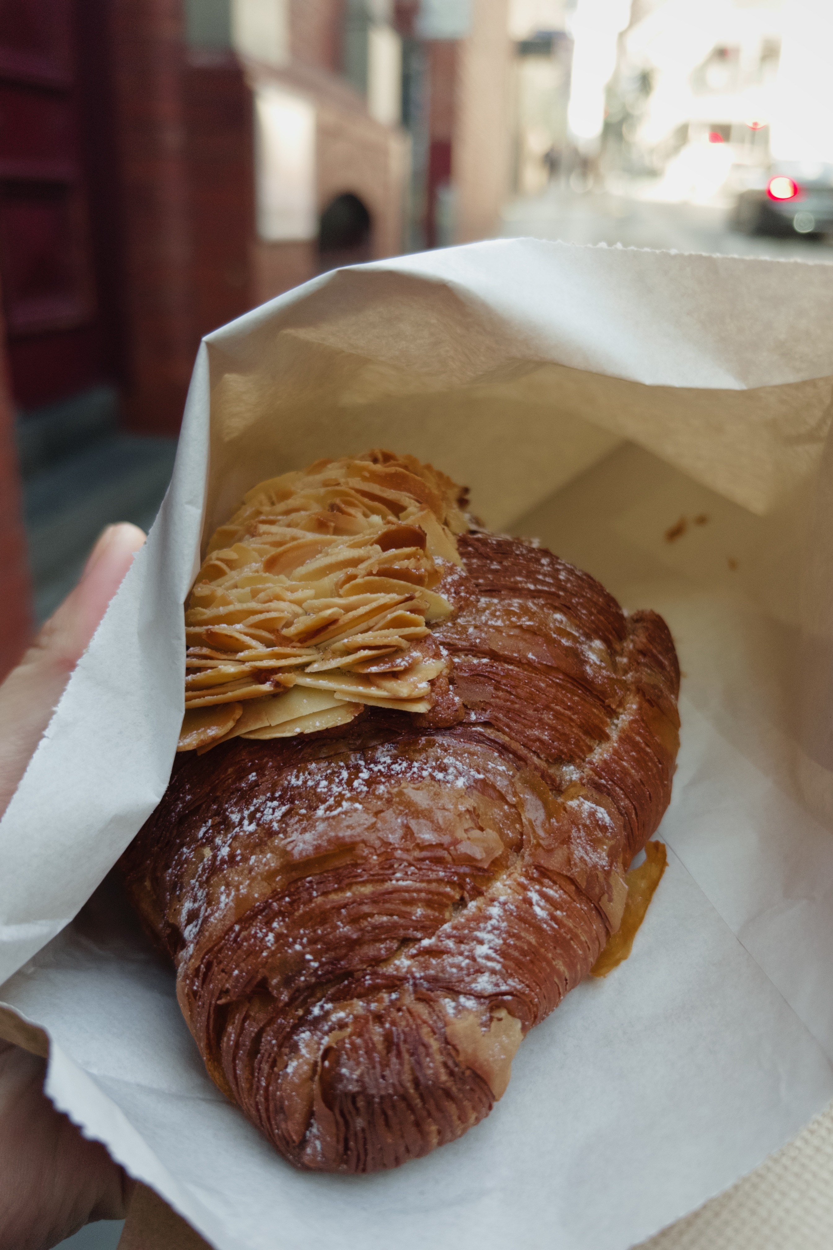 Close-up of a yellow tennis ball sitting on a green court, positioned near the white center line.