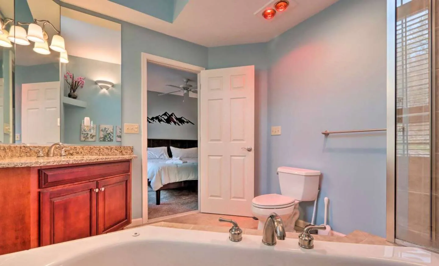 Primary bathroom with jetted tub, cherry vanity and doorway to the bedroom at SummitWind