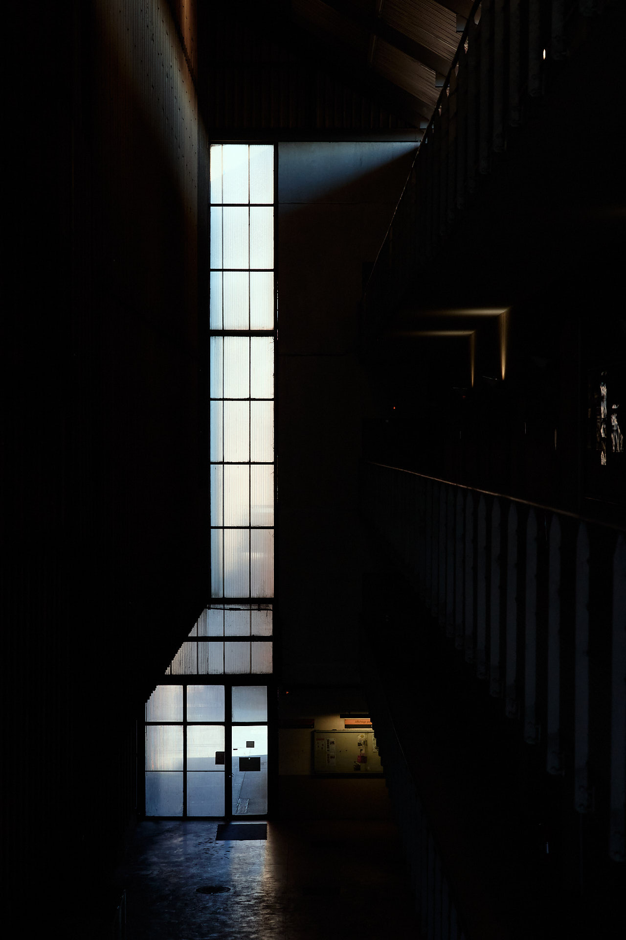 Hangar industriel ArcelorMittal avec une grue qui porte une pièce de remplacement d'un rouleau de laminoire.
