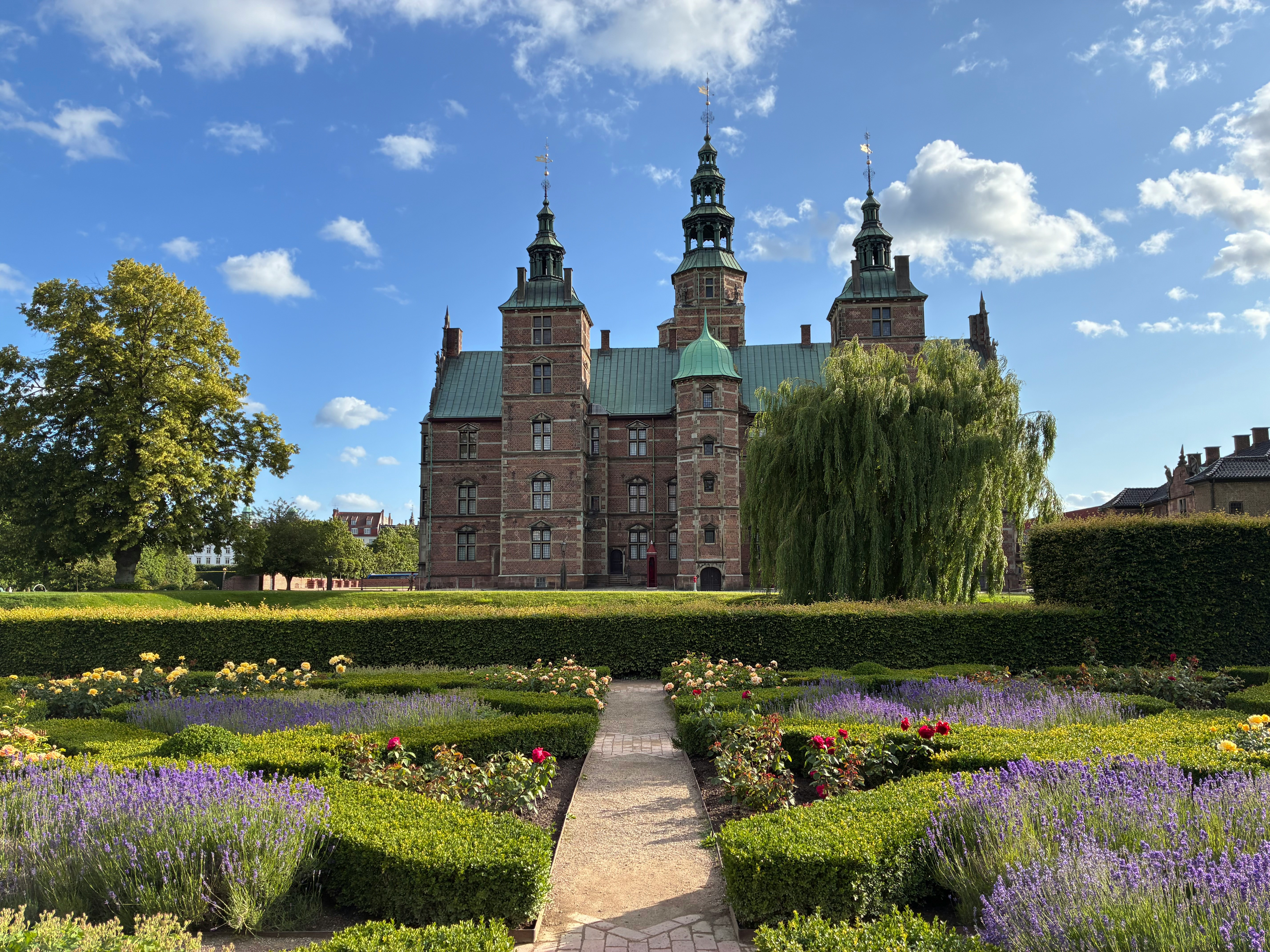 A historic castle with formal gardens on a sunny day