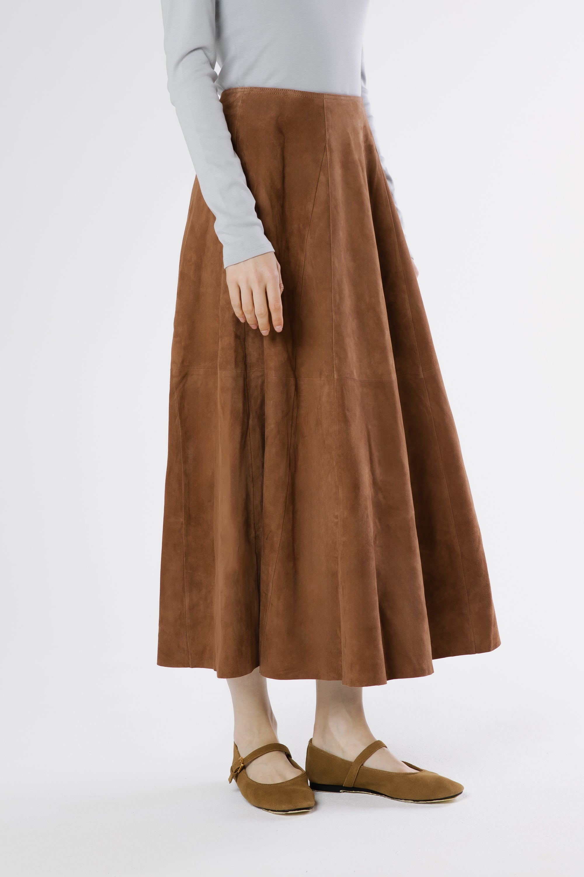 Side view of moca suede midi skirt with soft movement and structured silhouette