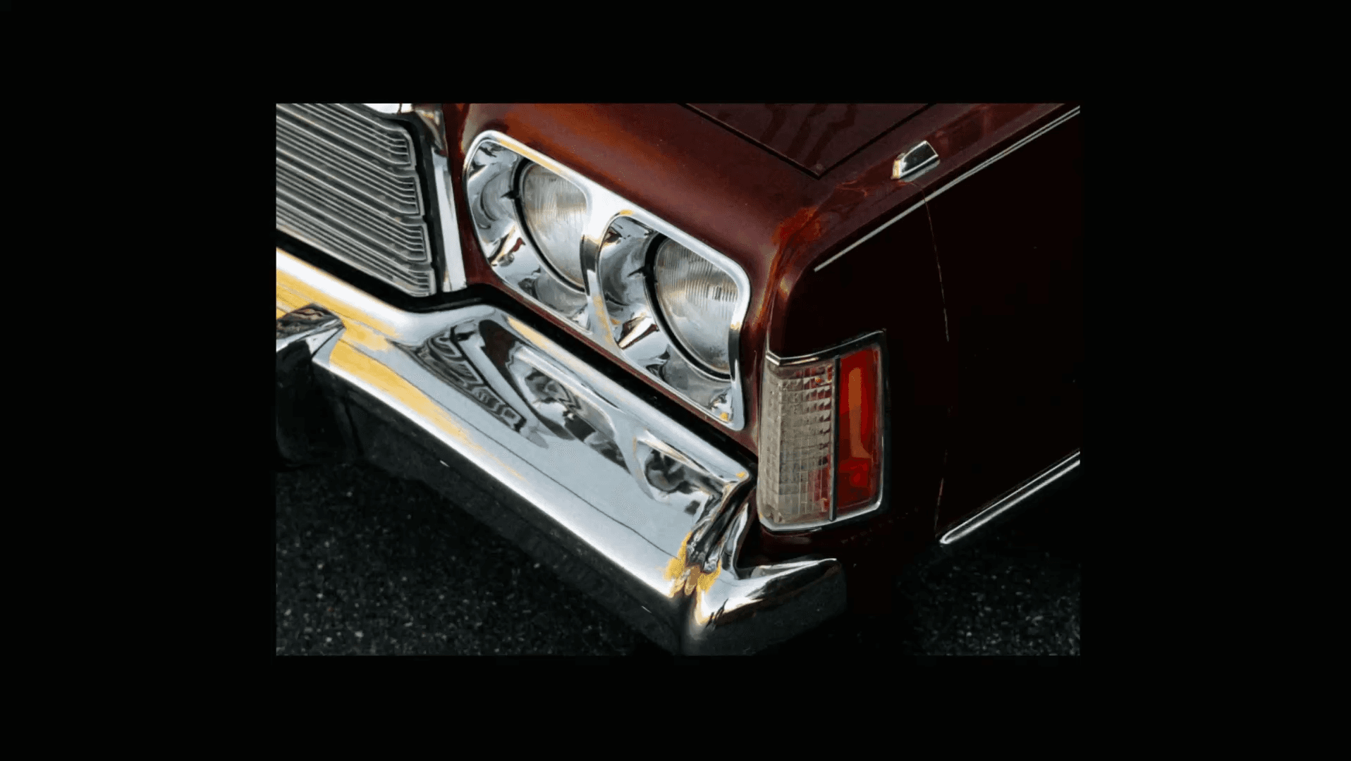 Classic burgundy car front with chrome bumper detail