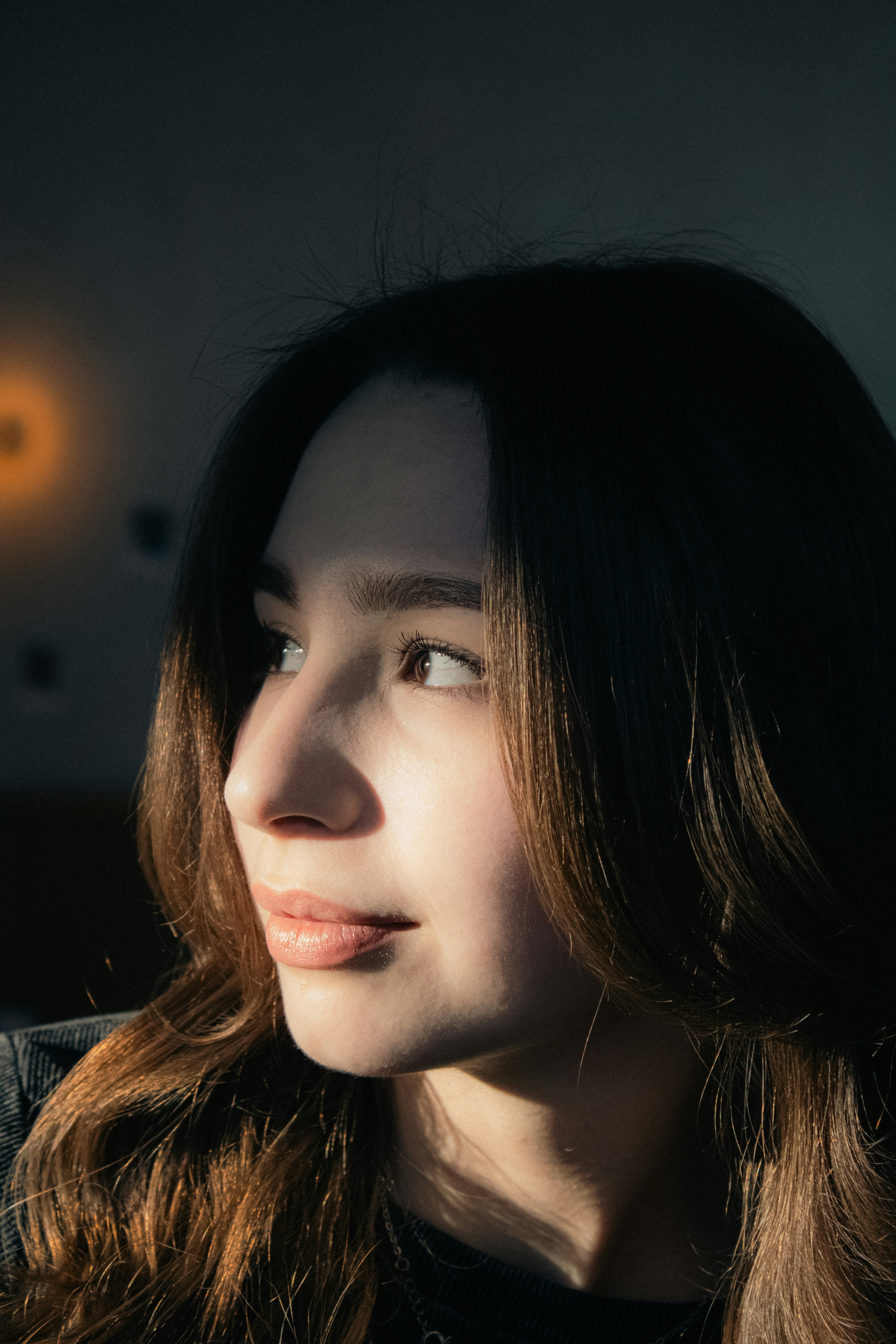 A young woman gazes into the sunlight.