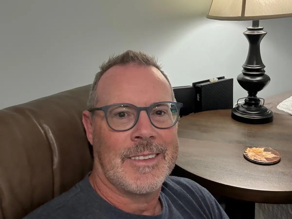 Stu sitting quietly in soft light, reflecting on recovery, resilience, and self-forgiveness.