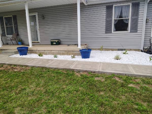 White decorative rock landscape bed along a concrete walkway and porch in Madison County, Indiana