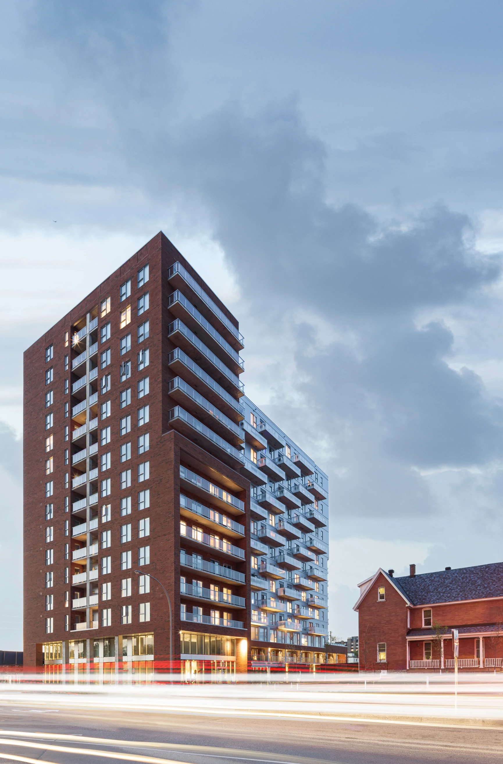 Exterior view of Éléonore residential complex, architectural photography showcasing brick and aluminum facade, integrating heritage and modern design.