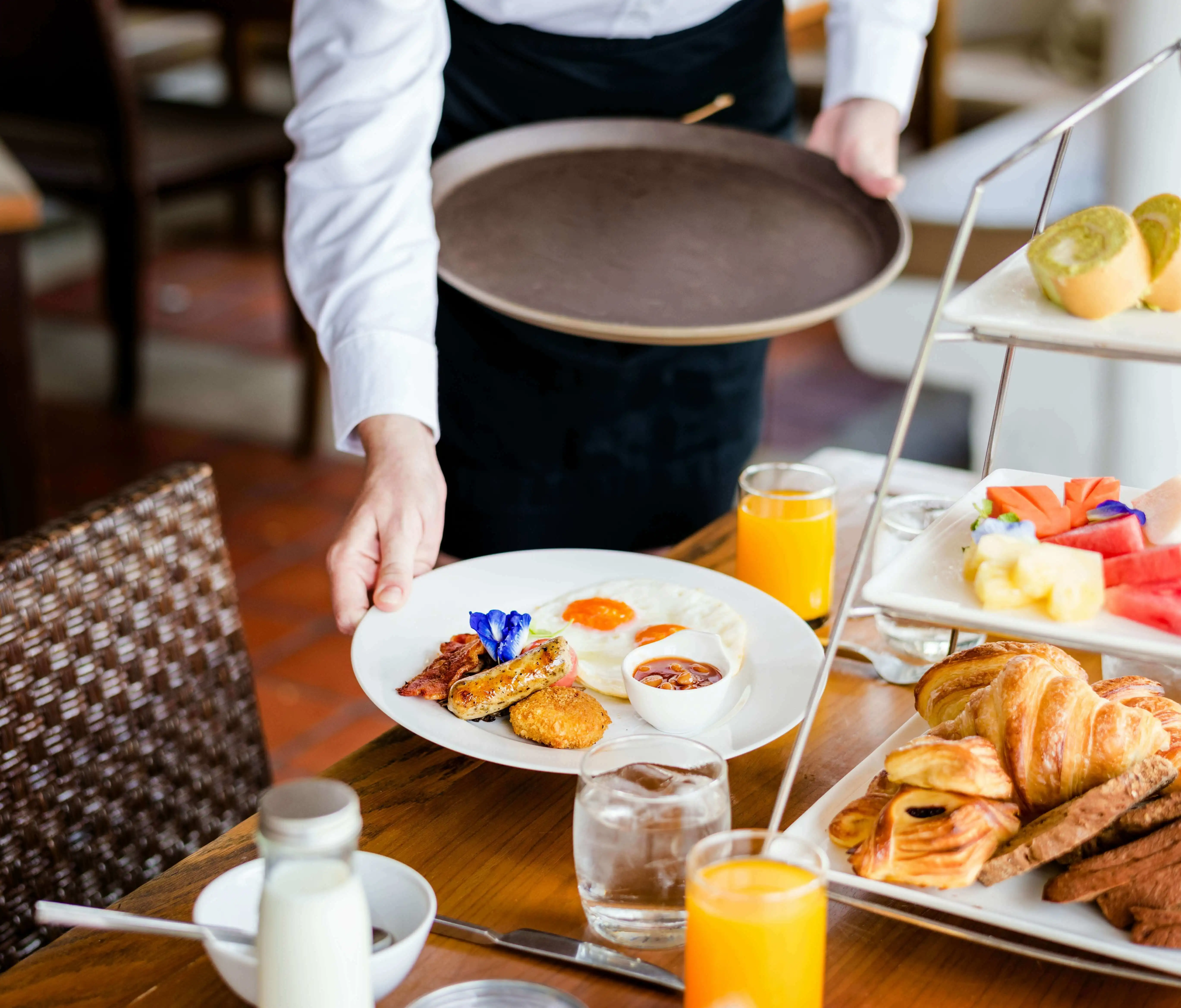 Staff taking an almost full plate from a guest’s table during buffet service time