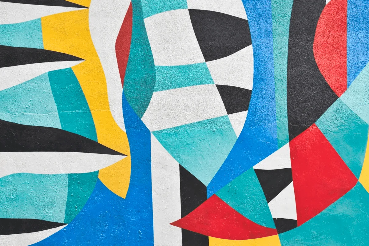 Colorful abstract geometric mural with bold shapes in teal, red, blue, yellow, black, and white