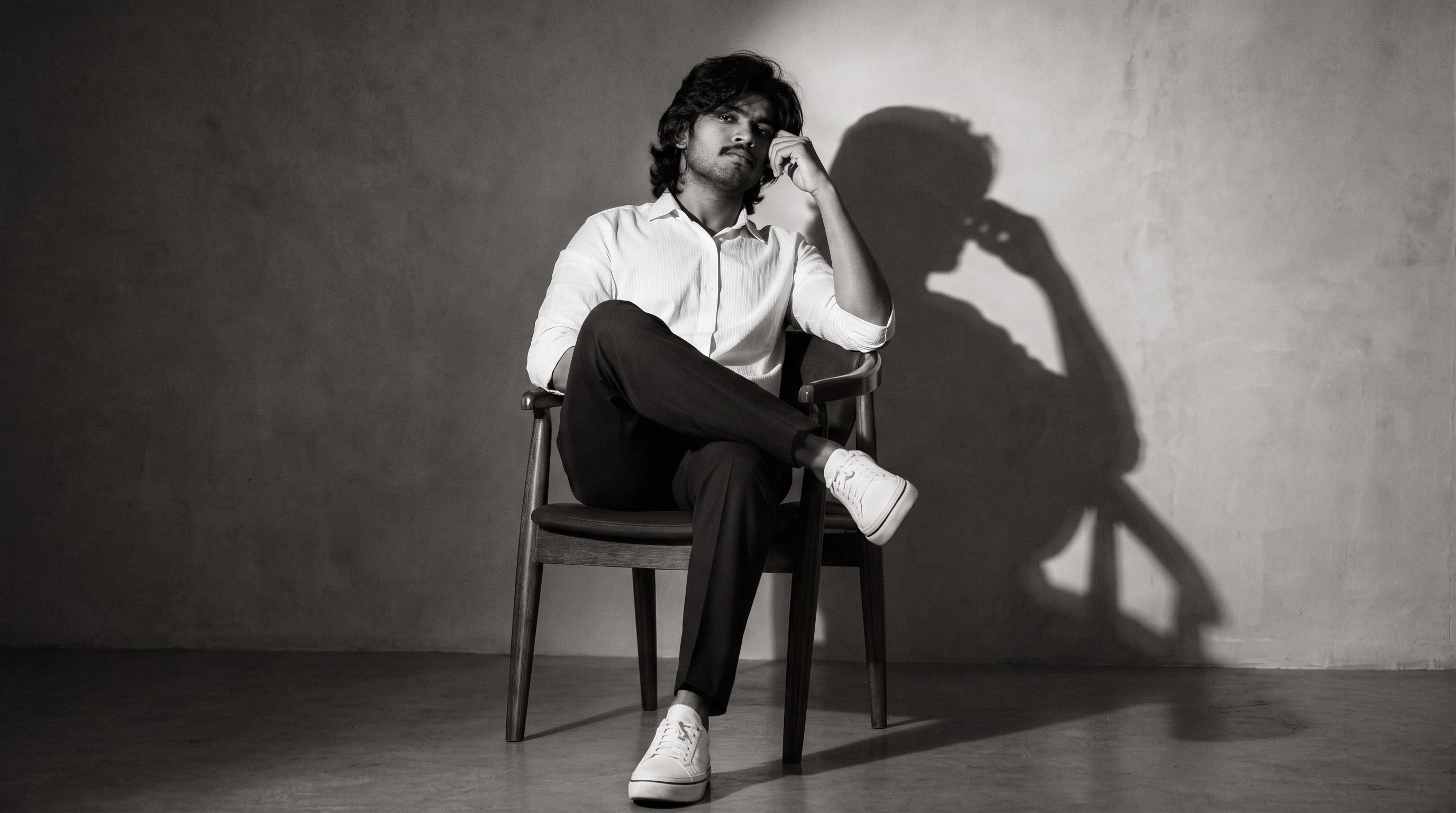 A person sitting on a chair,relaxed,confident.