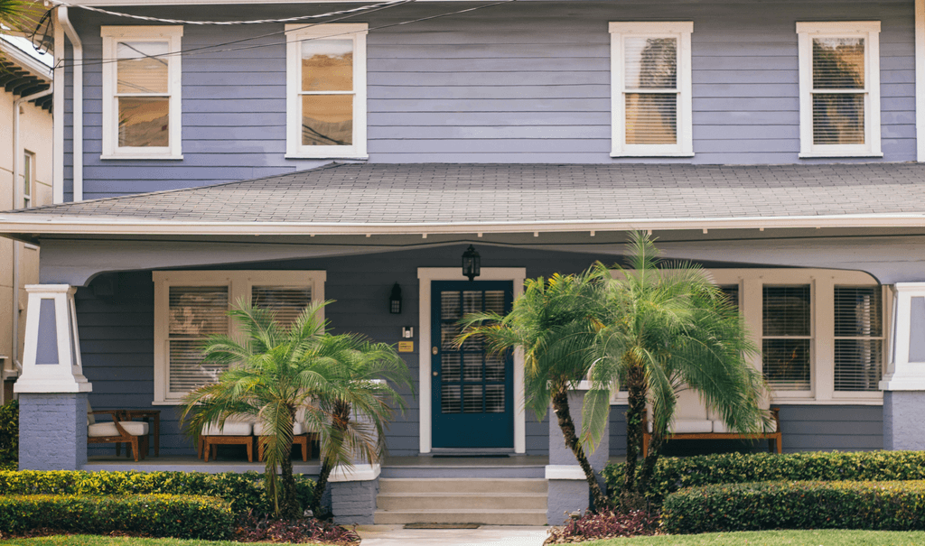 a blue house with palm trees in front of it