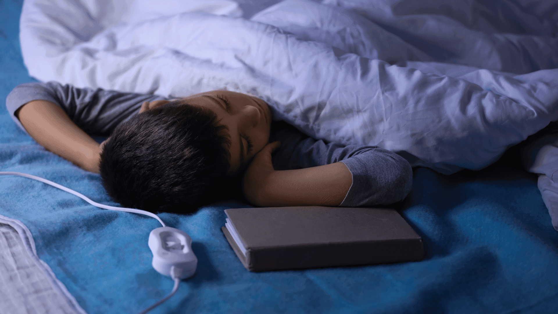 A young boy fast asleep in bed, looking peaceful and relaxed.