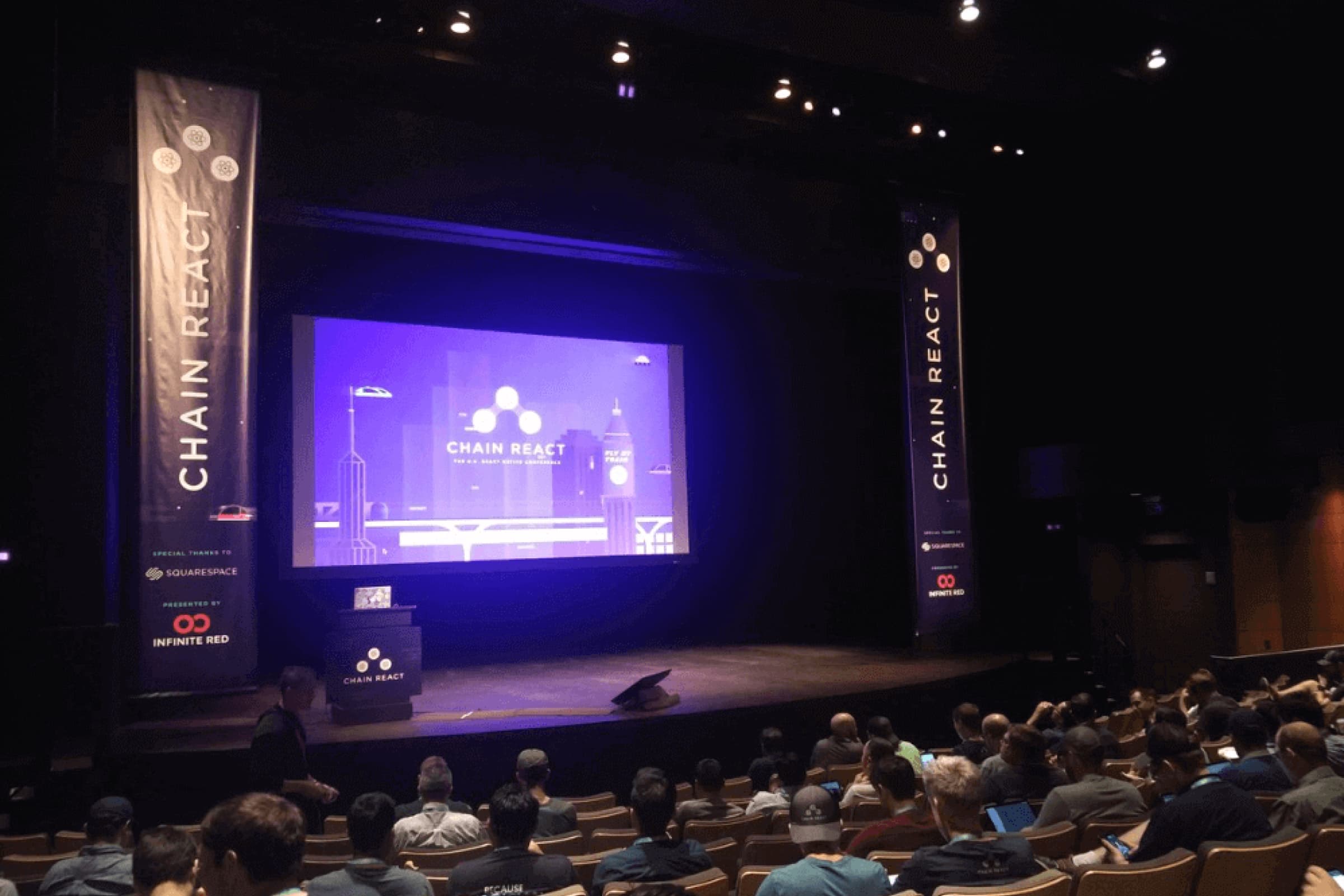 An event photo of KOMODO @ Chain React 2018, showing the audience looking at the stage area