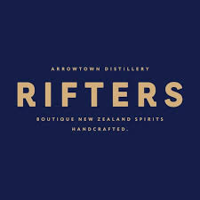 A person with short, curly blond hair wears a bright orange turtleneck sweater. The background is plain, creating a calm and focused portrait look.