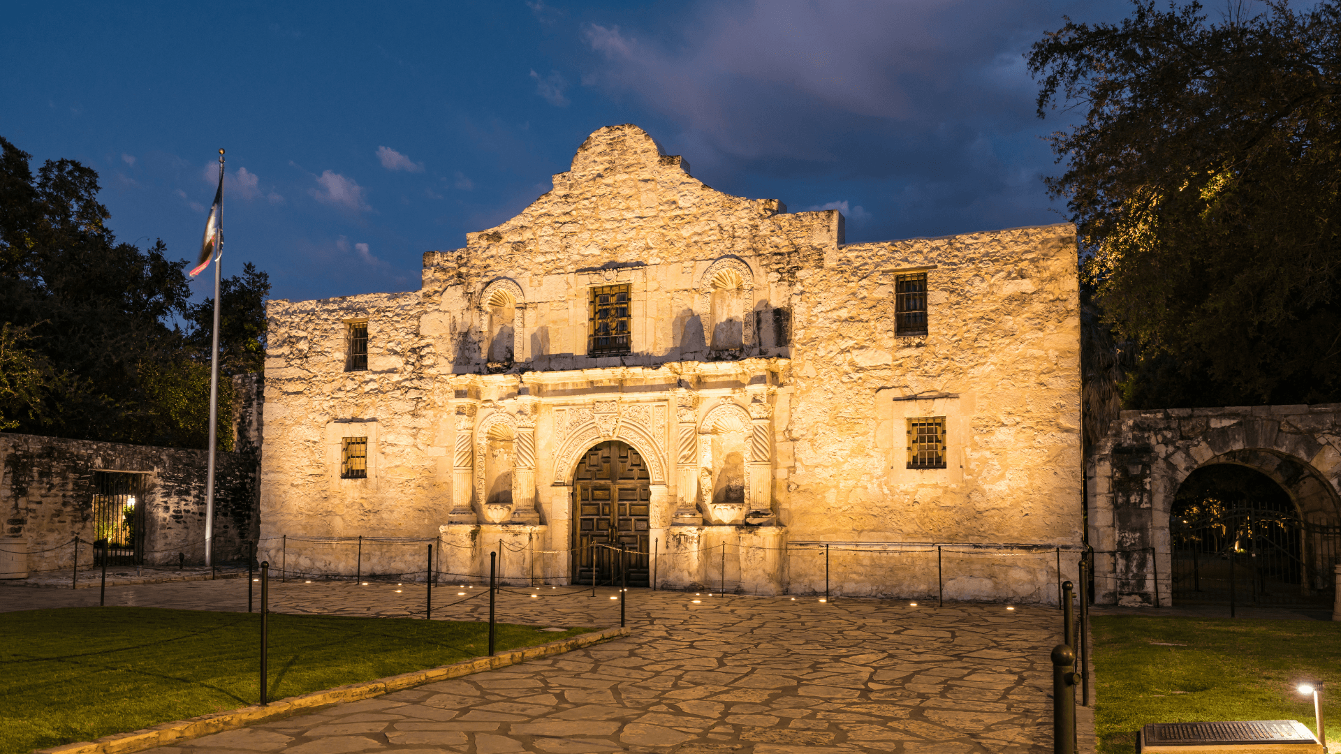 The Alamo illuminated at night, showcasing its historic architecture and surrounding landscape.