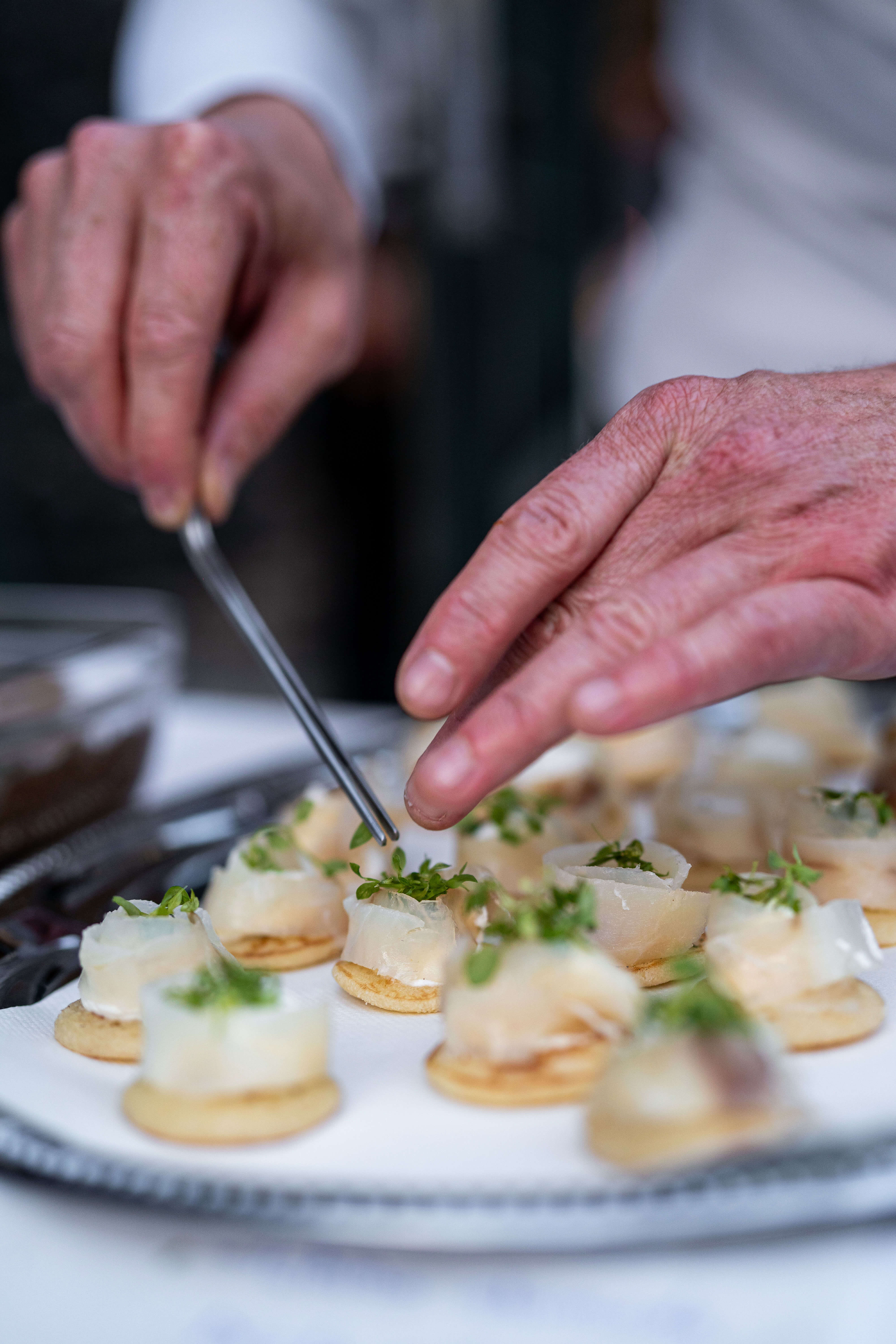 Manos de un chef preparando canapés
