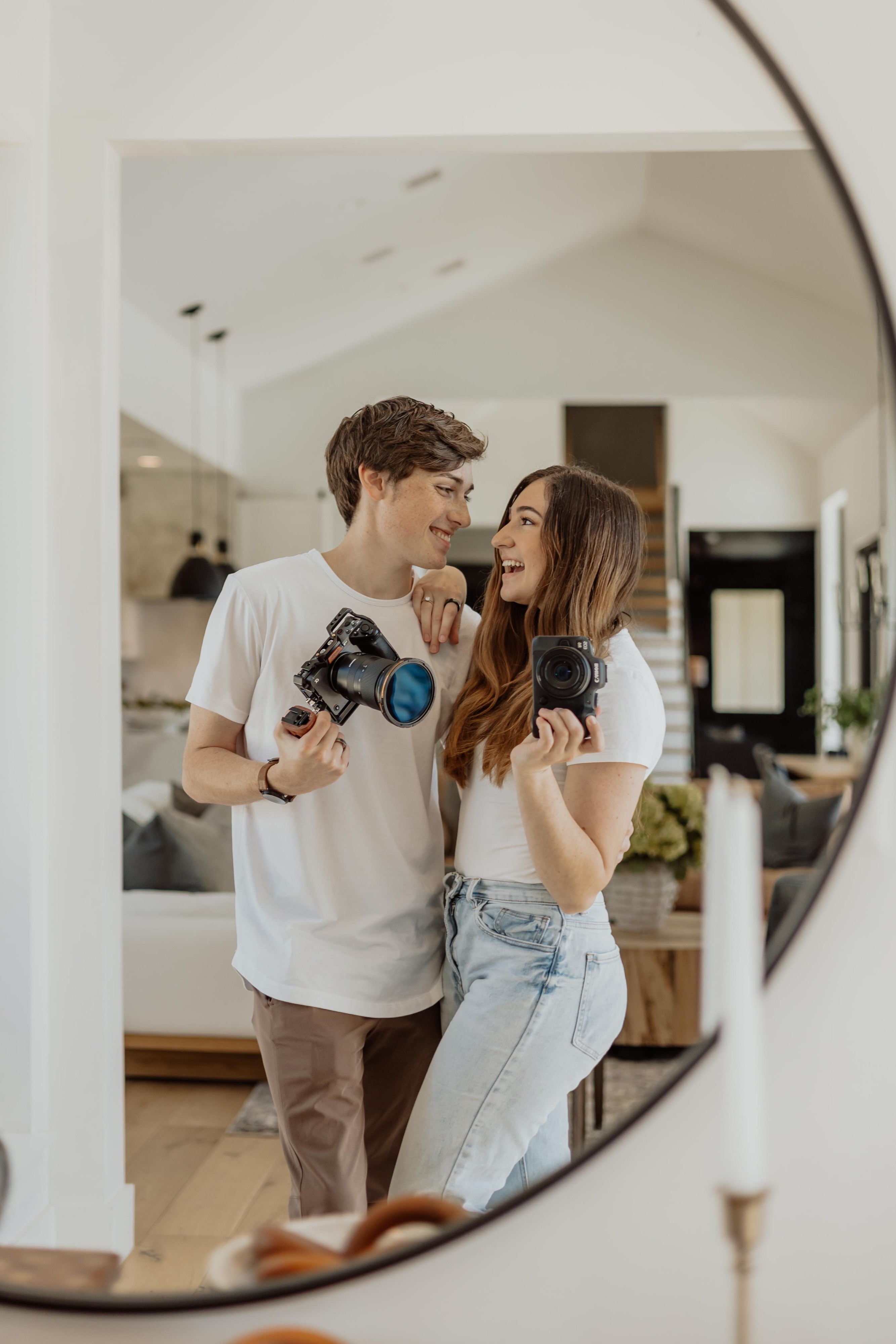 Picture of Duncan & Brianna in a white midcentry modern house looking at each other smiling