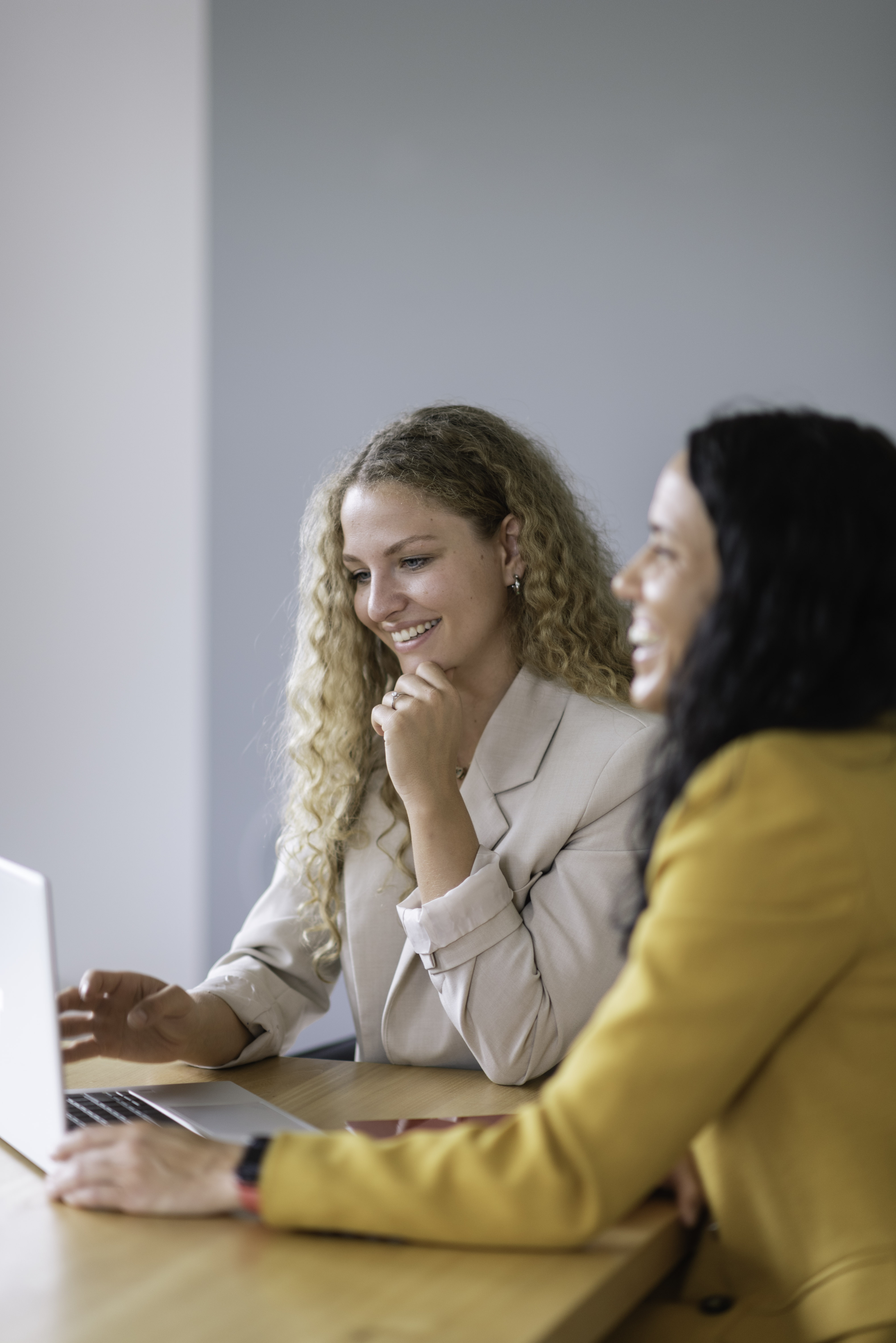 Zwei Frauen aus dem Team, die zusammen an einem Laptop arbeiten und den kollaborativen Geist des Unternehmens verkörpern.