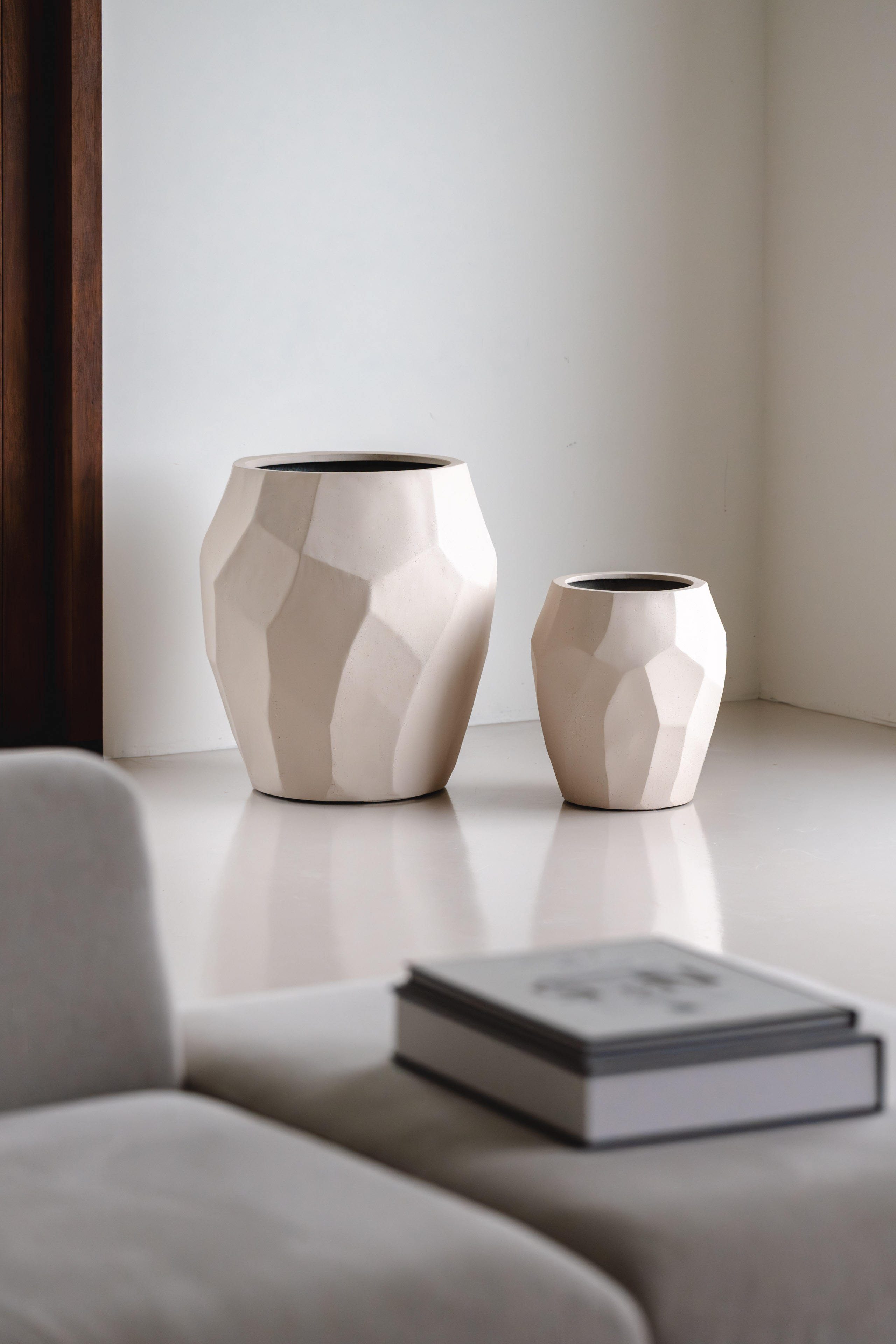 Luca Lifestyle Twee witte keramieken vazen met facetstructuur in een minimalistische studio-opstelling.