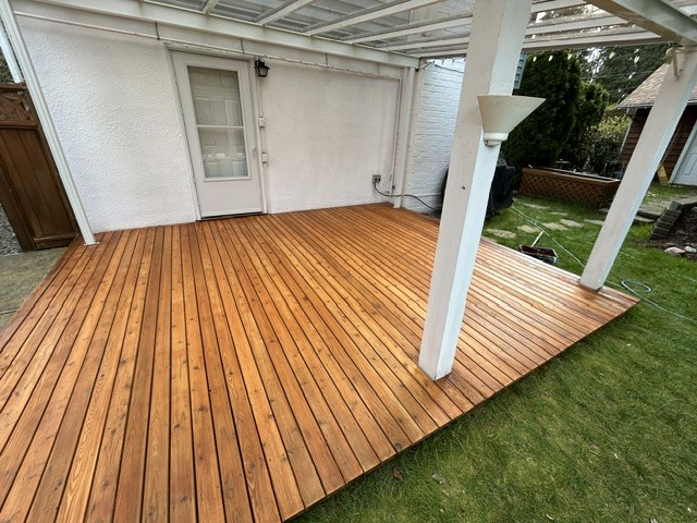 Completed exterior deck restoration showing the refreshed wood surface and surrounding home.