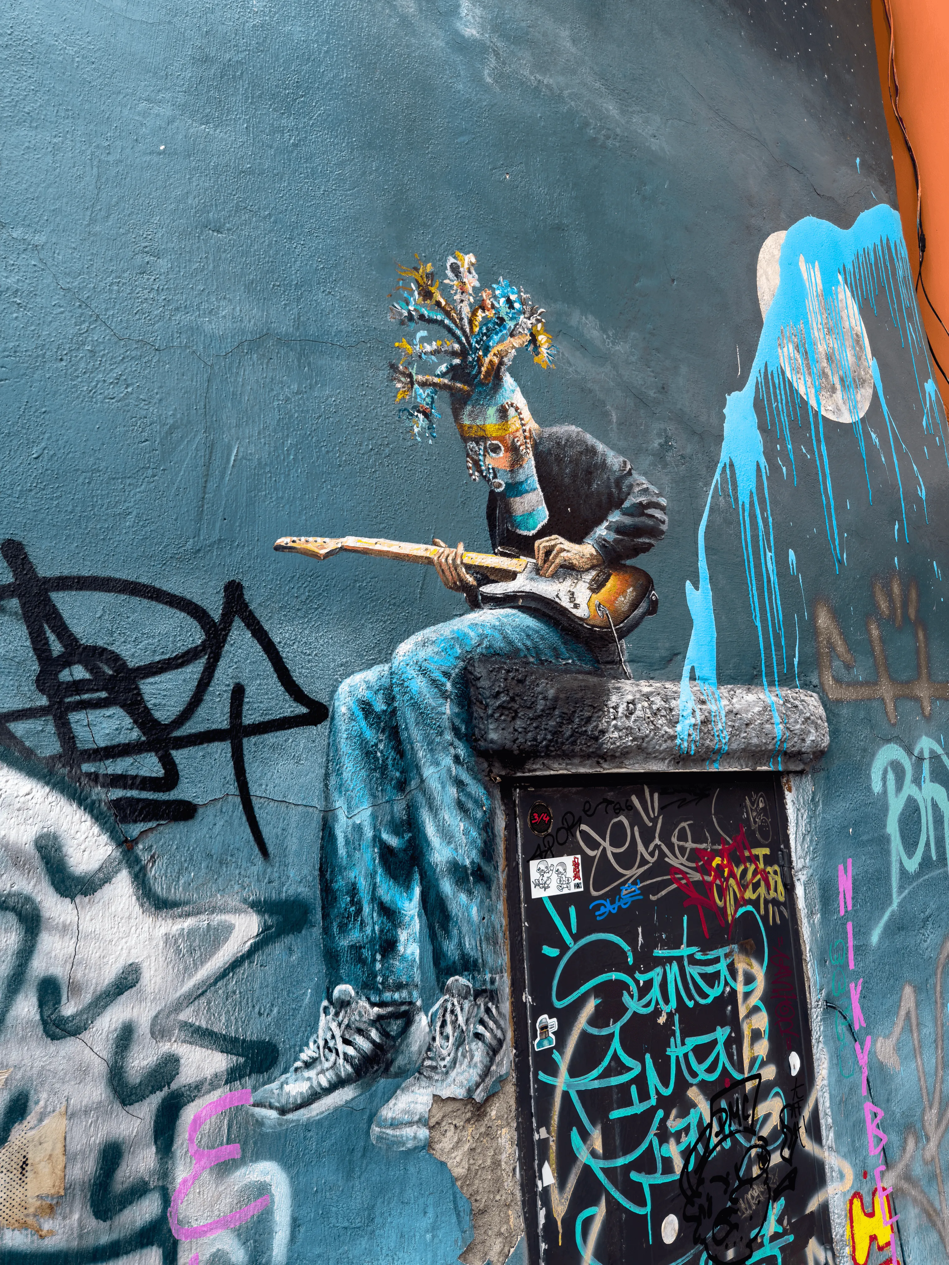 street-art d'un homme masqué avec une guitare dans les rues de Cuenca