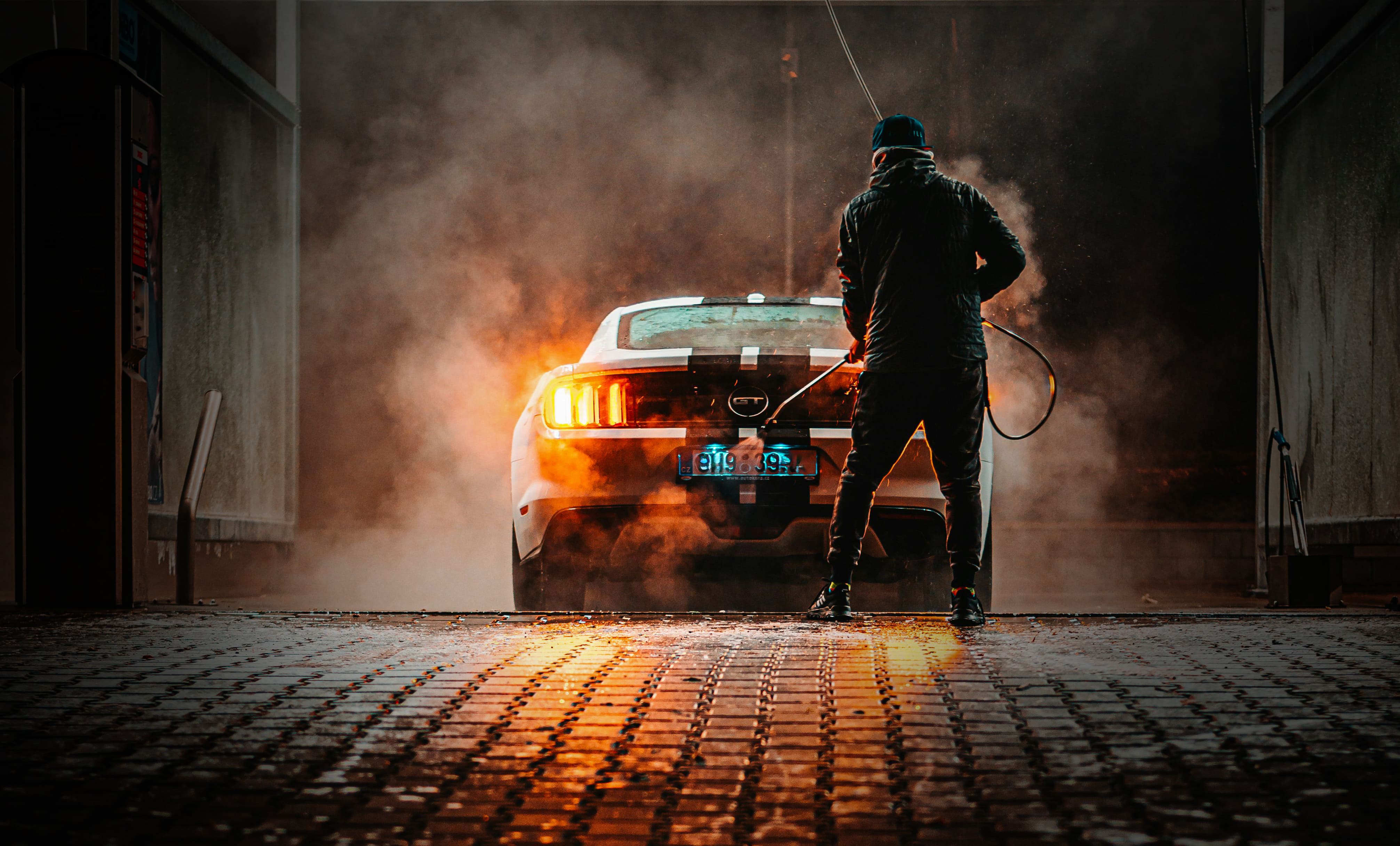 cleanege header dark image of a man from behind washing a gt car