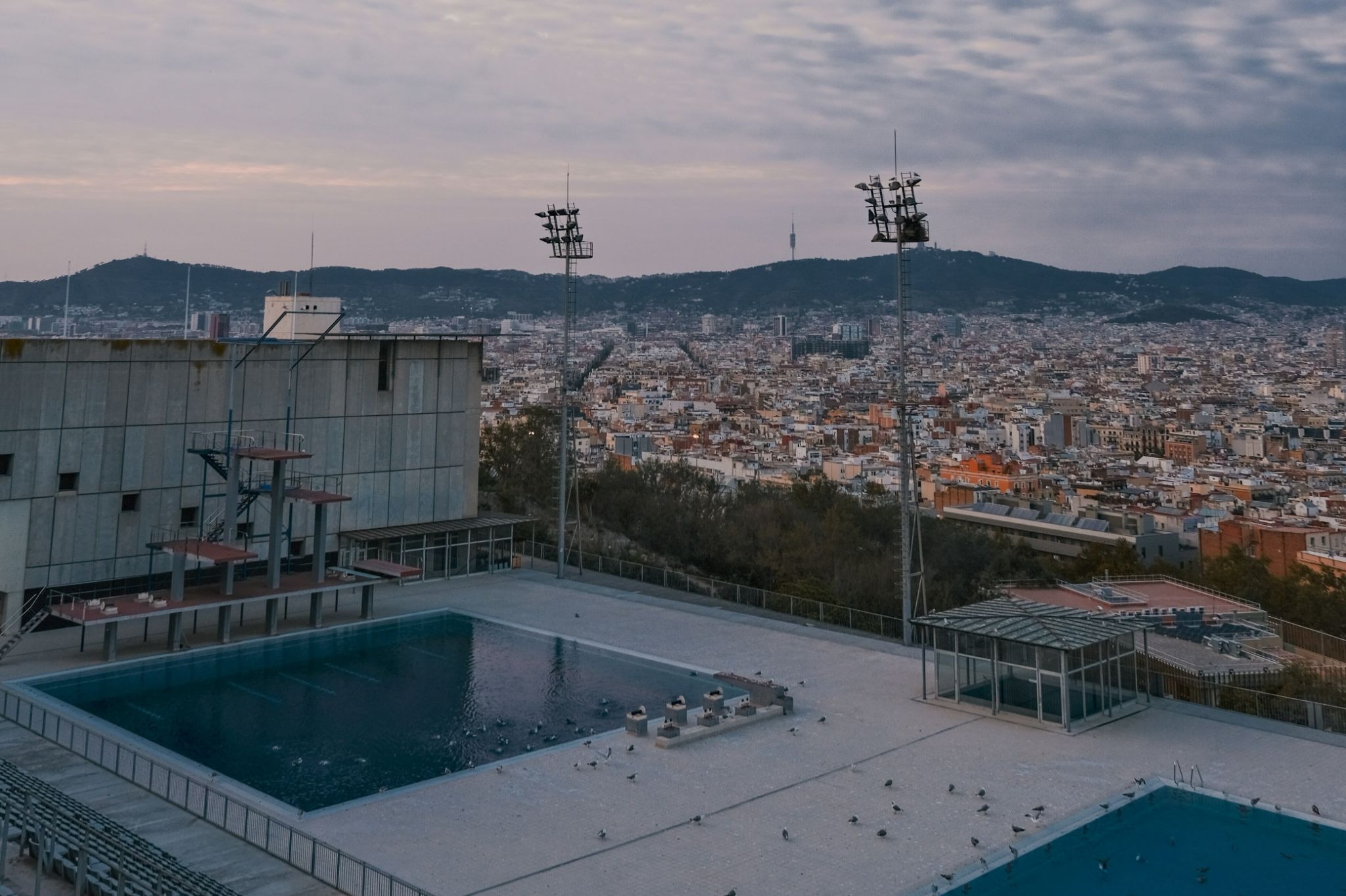 Two pools on Monjuïc hill, with the city of Barcelona in the background, and mountains behind